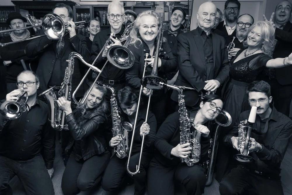 Foto von Bandmitglieder mit Blasinstrumenten.