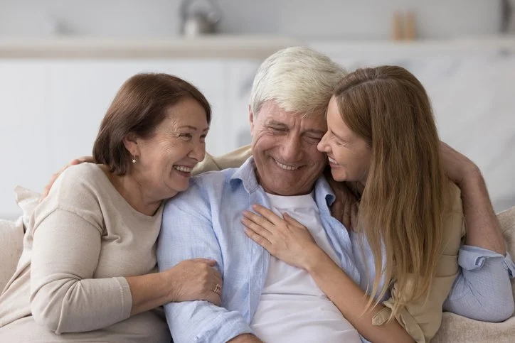 Adult woman hugging her senior parents