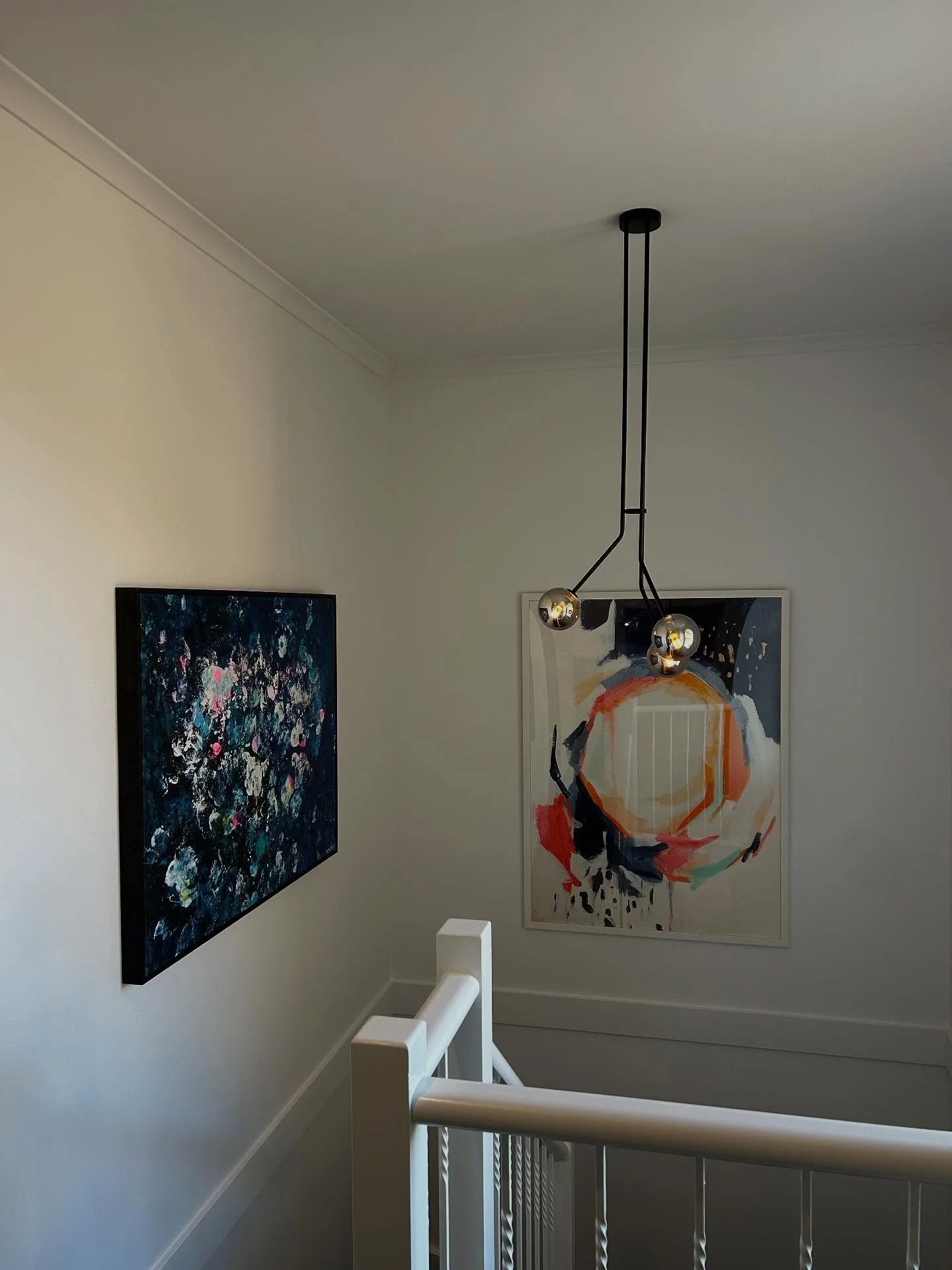 Replaced a staircase pendant light and also hung some art pieces.