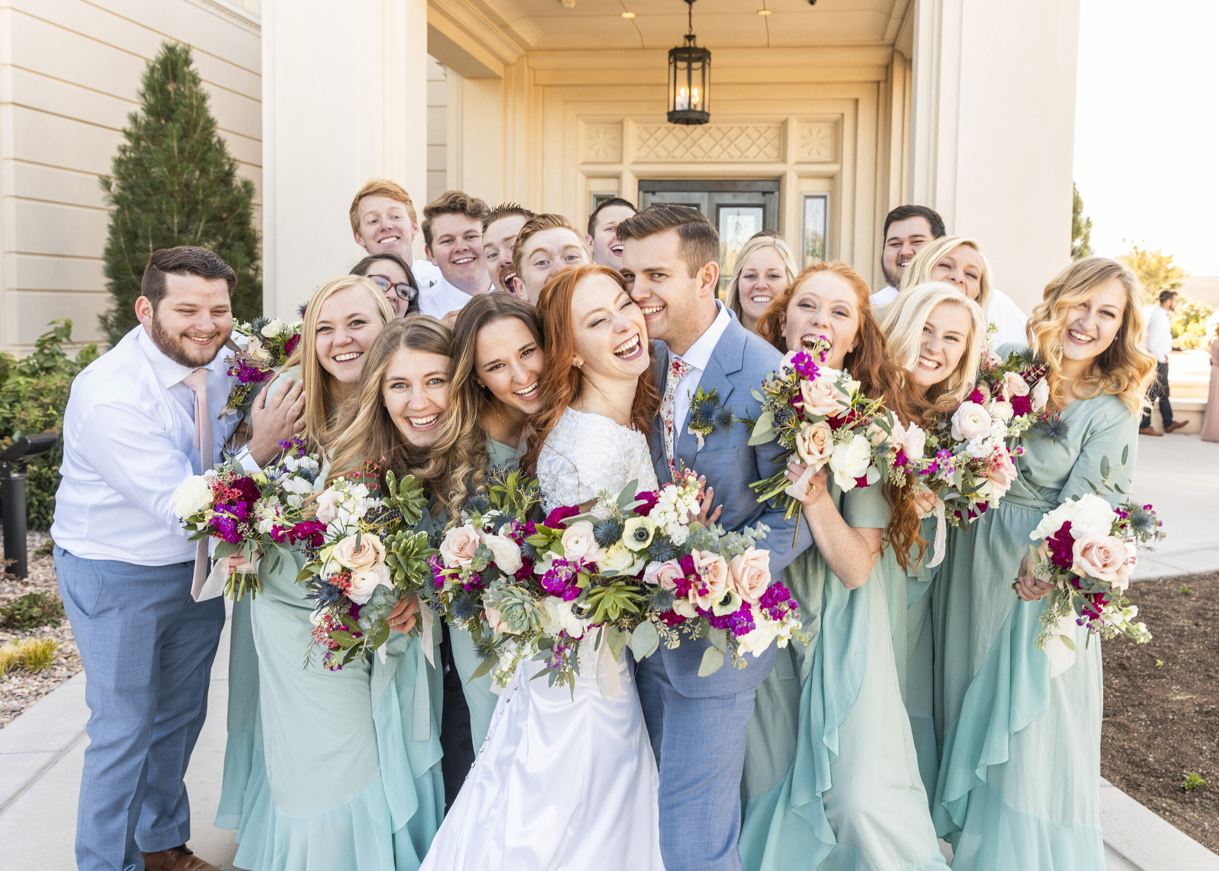  celebrating the happy couple wedding guests surrounding the glowing couple wedding party and bride and groom pose inspiration wedding color inspiration blue and hot pink bouquet inspiration wedding hair style inspiration lds wedding inspiration summ