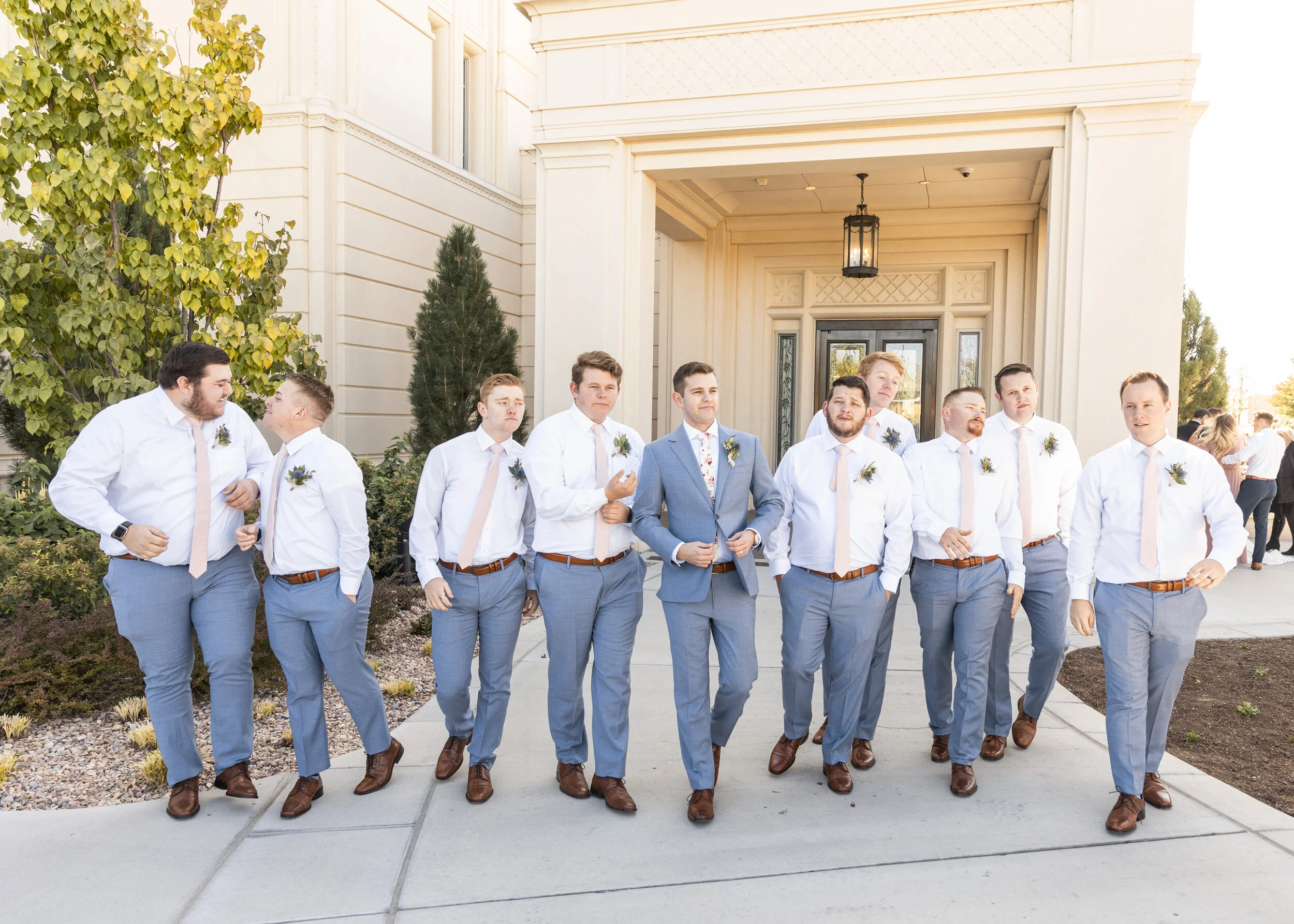  grooms men matching the groom groom attire inspiration cohesive groom and groomsmen look blue suit groom wedding attire inspiration wedding style inspiration groom walking with his groomsmen pose inspiration unique wedding picture ideas brown shoes 