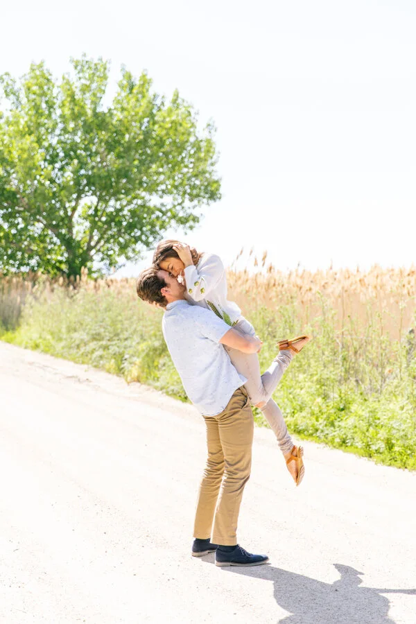  adorable couple lift and kiss pose inspiration beautiful bright colors photo shoot on the road beautiful bright and airy engagement session photo shoot client outfit inspiration what to wear on your engagement photo shoot inspiration beautiful brigh
