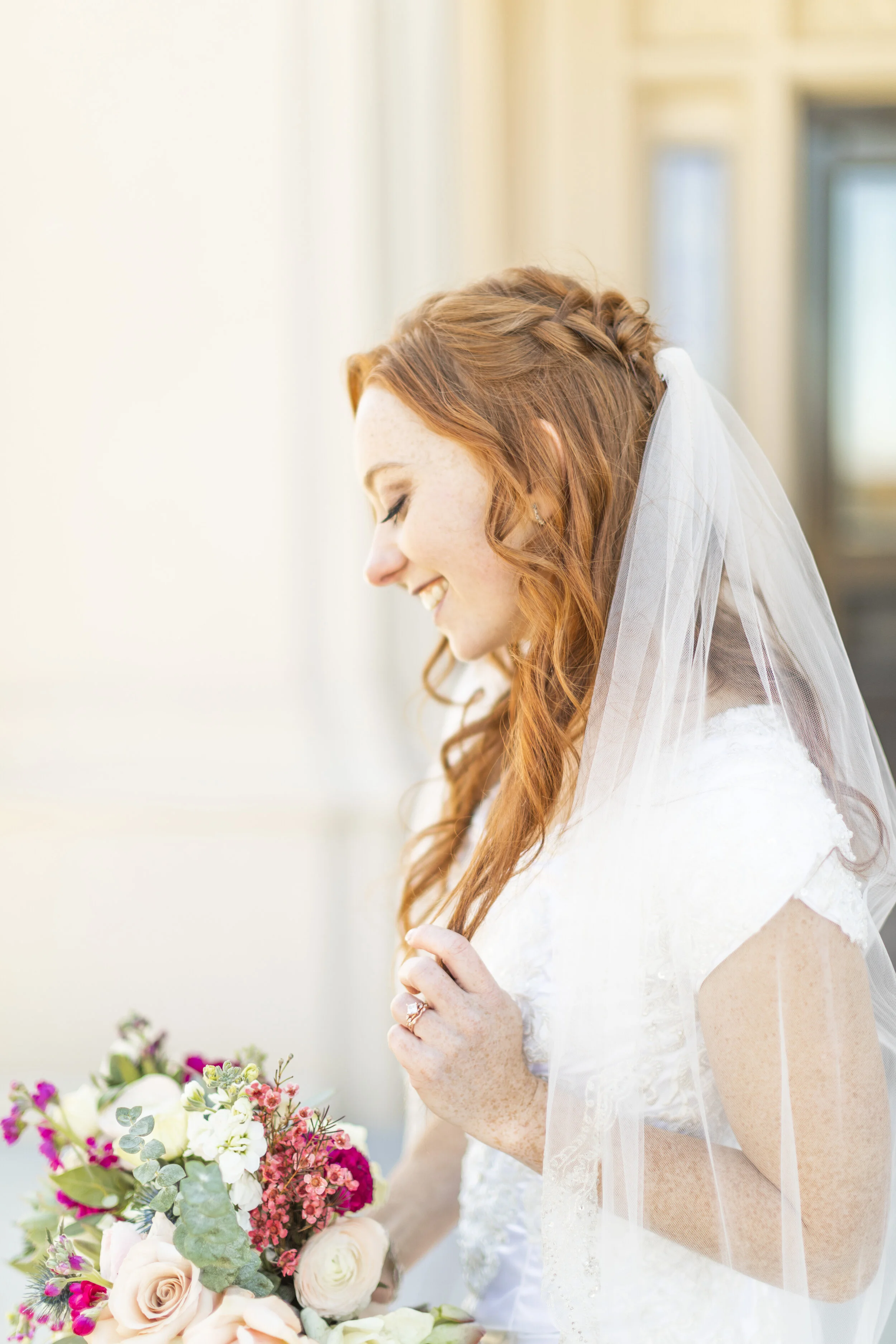  gorgeous bridal photo shoot session happy bride happy day wedding day photo shoot bridal hairstyle inspiration half up and half down curls beautiful profile picture bride looking at her bouquet idea on how to wear your wedding veil summer wedding at
