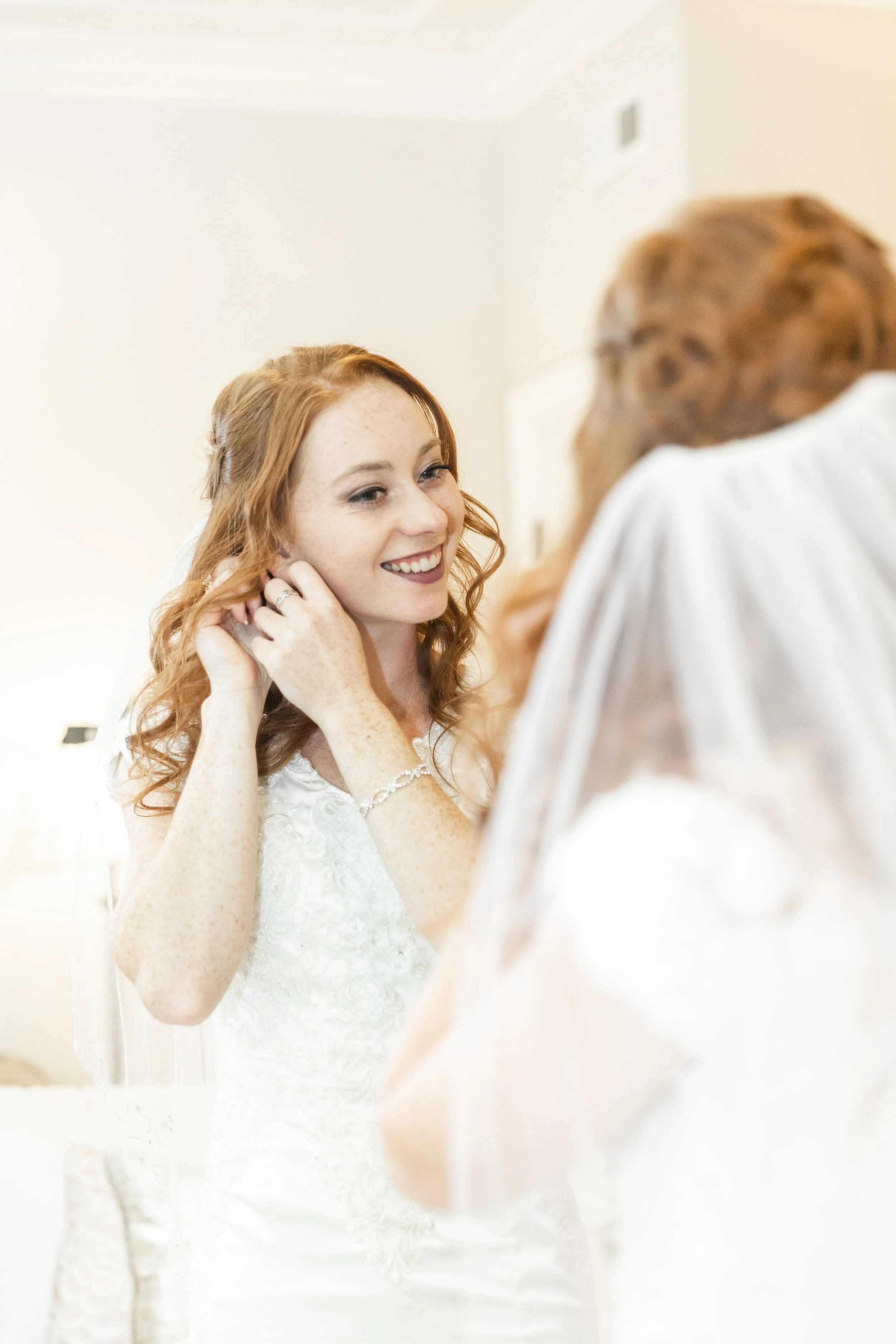  bridals bride getting ready for her big day pose inspiration wedding photography inspiration bright light and airy putting on her wedding day earrings happy bride radiant bride before the wedding wedding photography inspiration getting ready before 