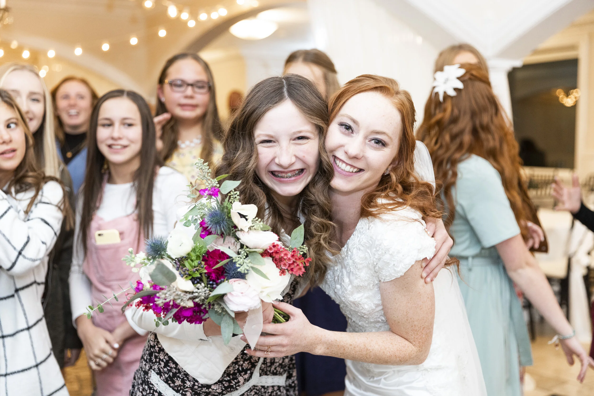  bride with the guests wedding reception photography pose inspiration beautiful red headed bride wedding party guest who caught the bouquet shes getting married next wedding tradition pose inspiration wedding party wedding reception wedding guest wed