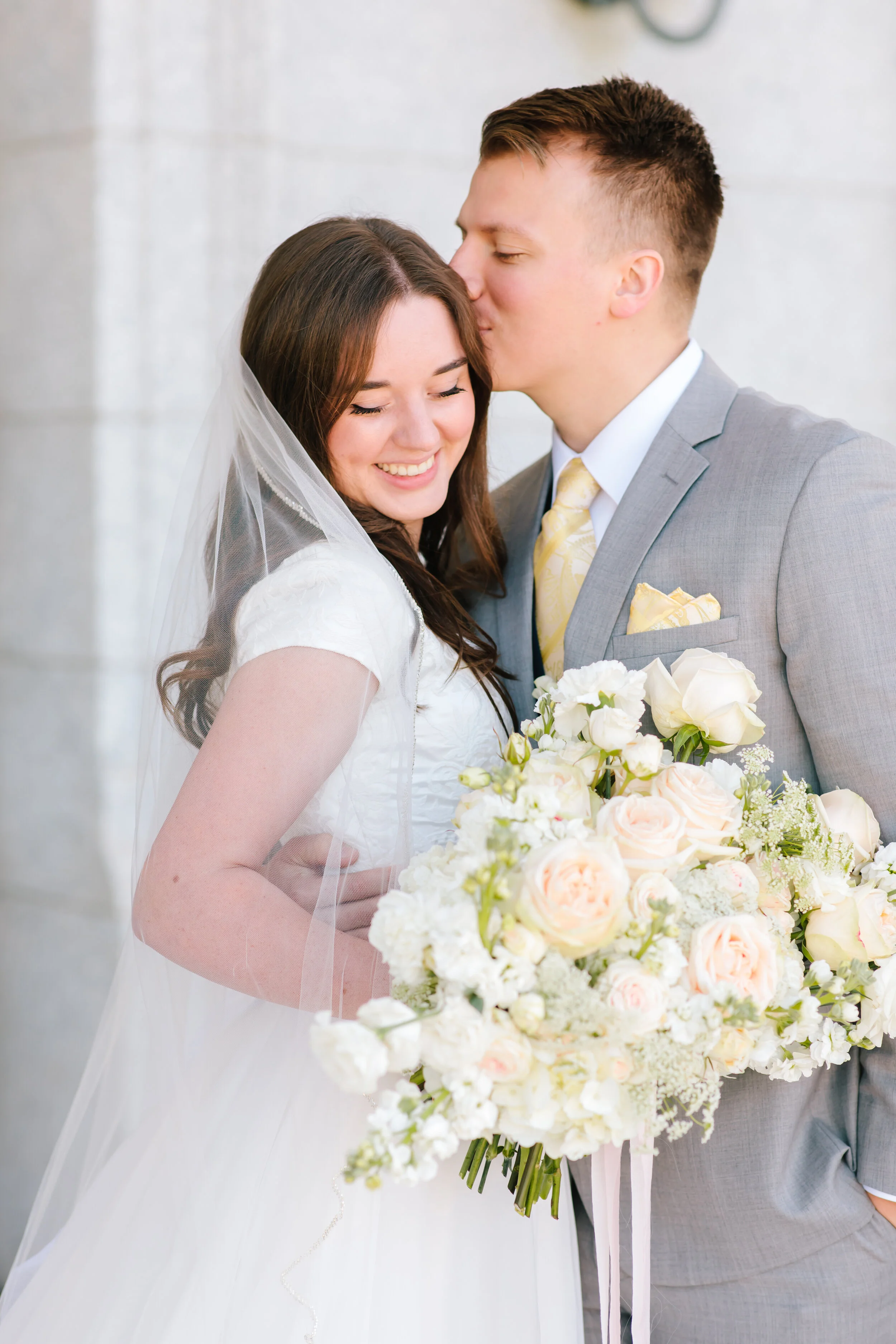  gorgeous florals wedding bouquet inspiration groom attire inspiration soft peach tie and pocket square short sleeved a line wedding dress inspiration couple goals husband holding and kissing wife pose inspiration couple pose inspiration lds wedding 