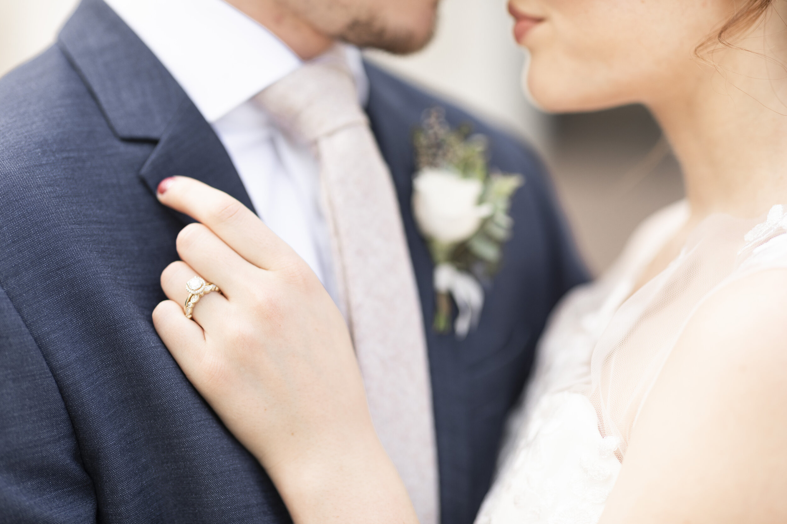  soon to be wife holding soon to be husbands lapel romantic close up pose inspiration wedding ring inspiration single white rose boutonniere inspiration   dark blue suit light lavender tie wedding color inspiration wedding dress inspiration wedding g