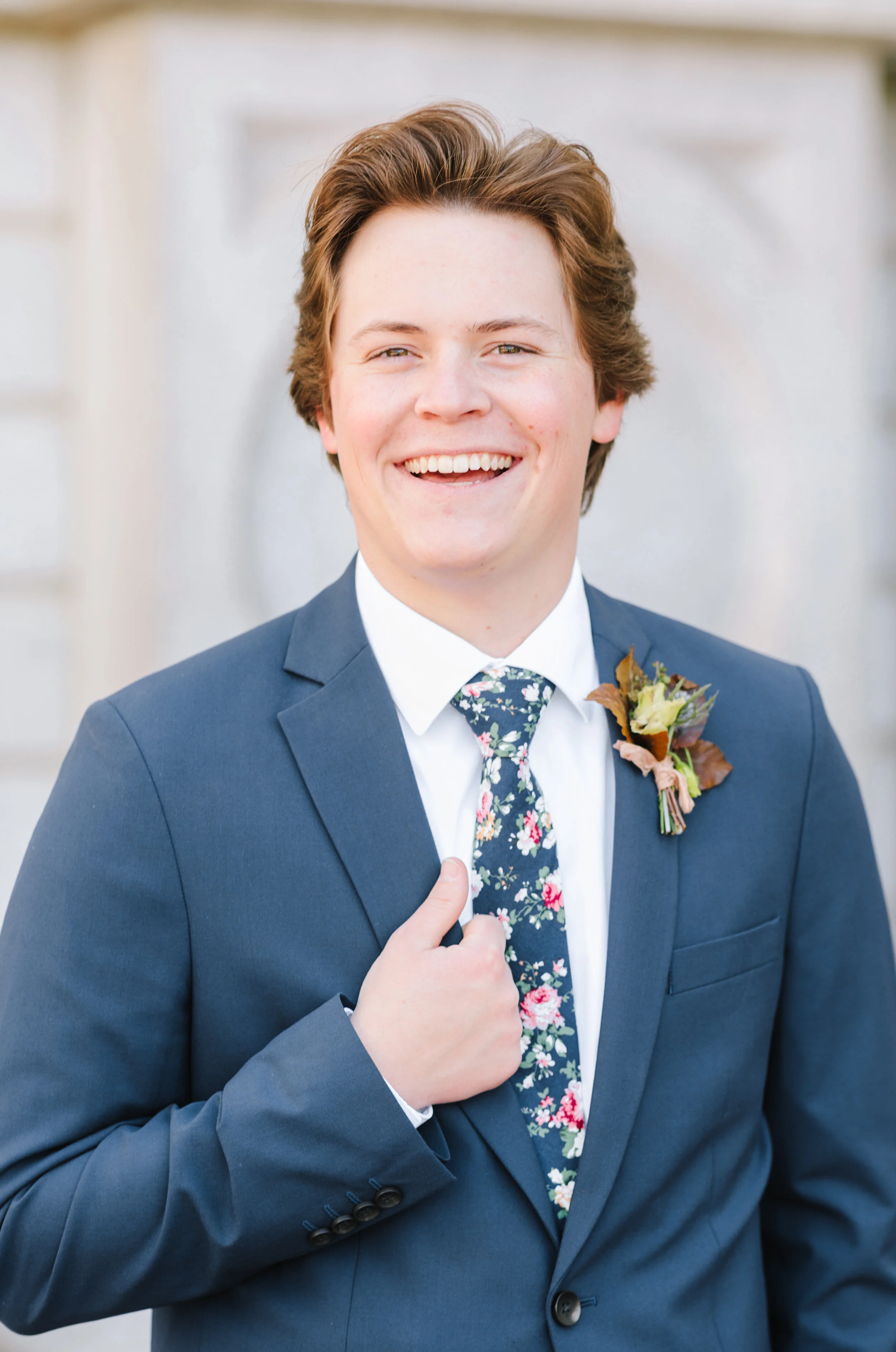  groom pose inspiration holding the jacket lapel groom aesthetic inspiration groom hairstyle inspiration navy blue suit and tie floral tie inspiration wedding attire goals fall boutonniere inspiration just the groom wedding day photo shoot inspiratio