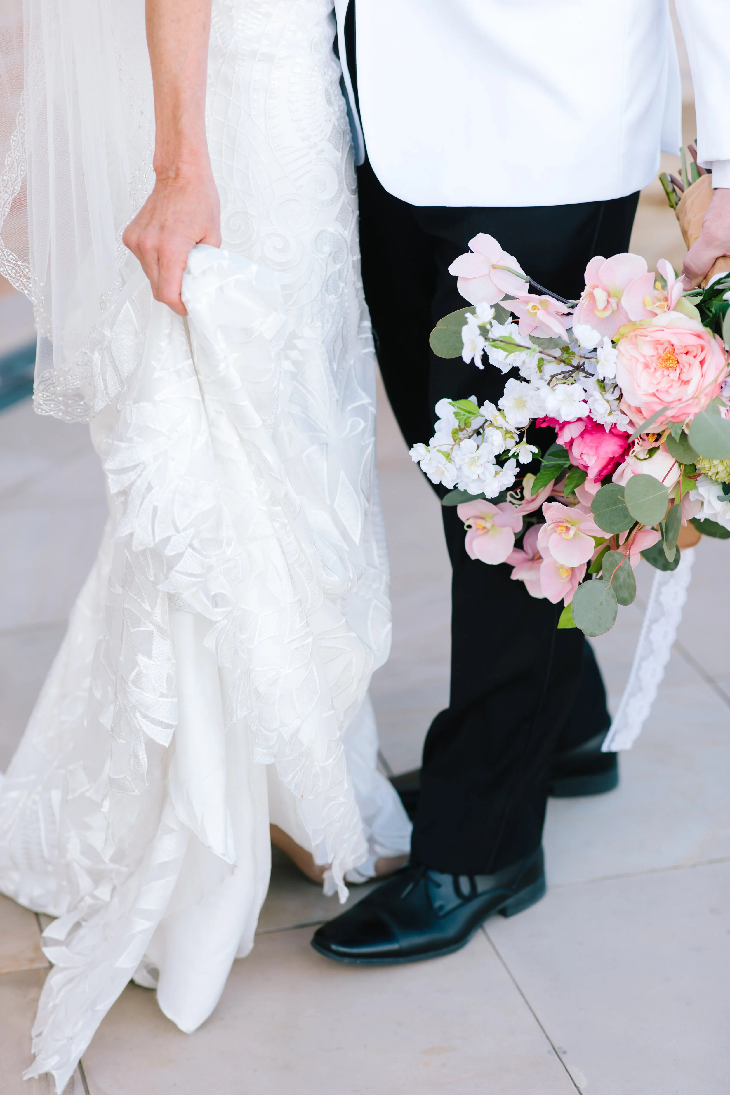  holding the wedding dress train close up wedding photo shoot inspiration close up on the dress and bouquet husband holding the bouquet bouquet inspiration soft pink flowers wedding color inspiration wedding photo shoot goals  wedding attire utah #we