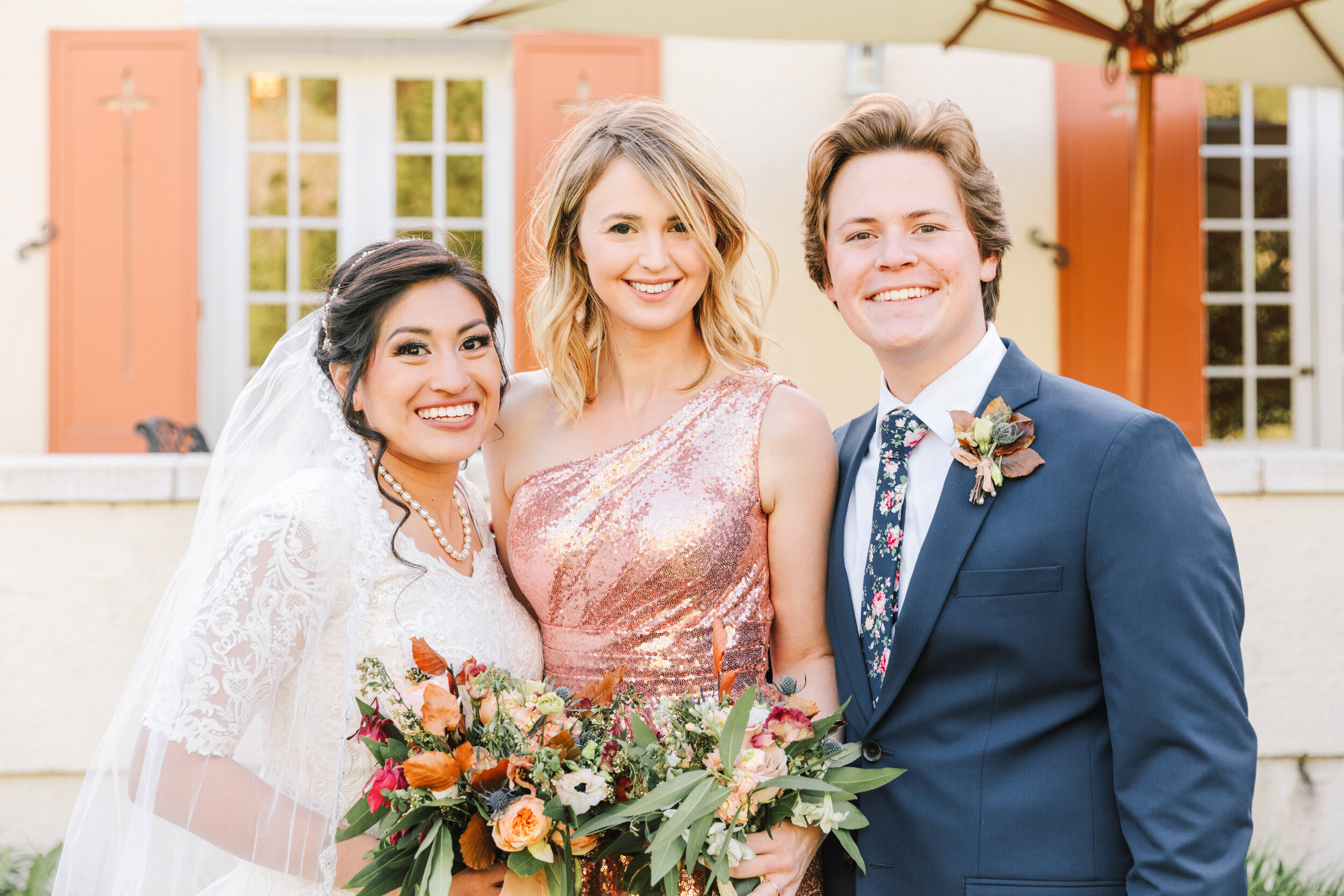  bridesmaid with the bride and groom shiny sequined bridesmaids dress picture with the happy couple picture with the bride and groom wedding bouquet inspiration warm colors beautiful wedding color inspiration wedding day photo shoot happy couple newl