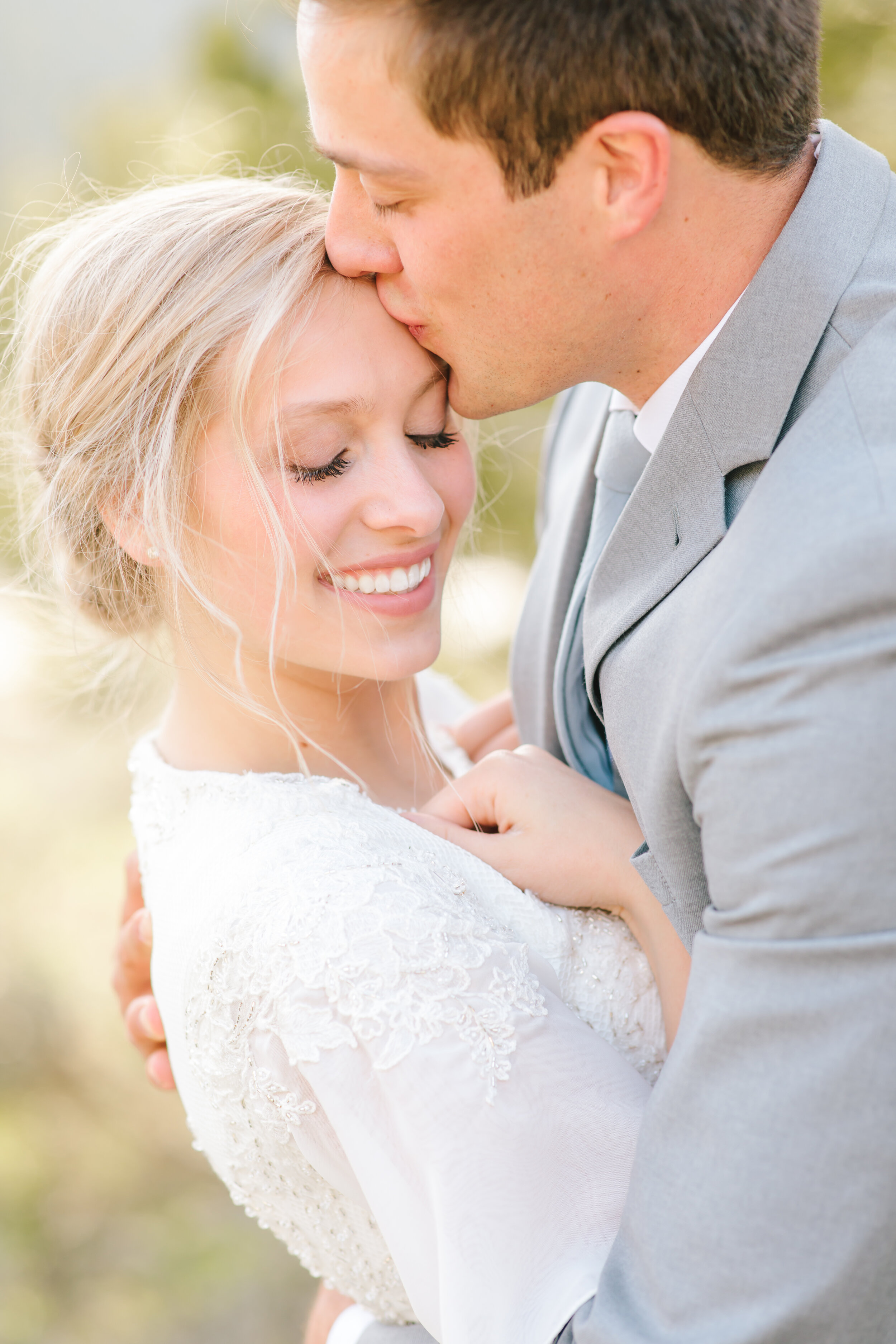  sweet romantic kiss on the forehead lds bride mormon bride mormon couple sealed for time and all eternity elegant bridal hairstyle inspiration light grey tux light grey wedding suit groom attire inspiration bridal attire inspiration couple goals   #