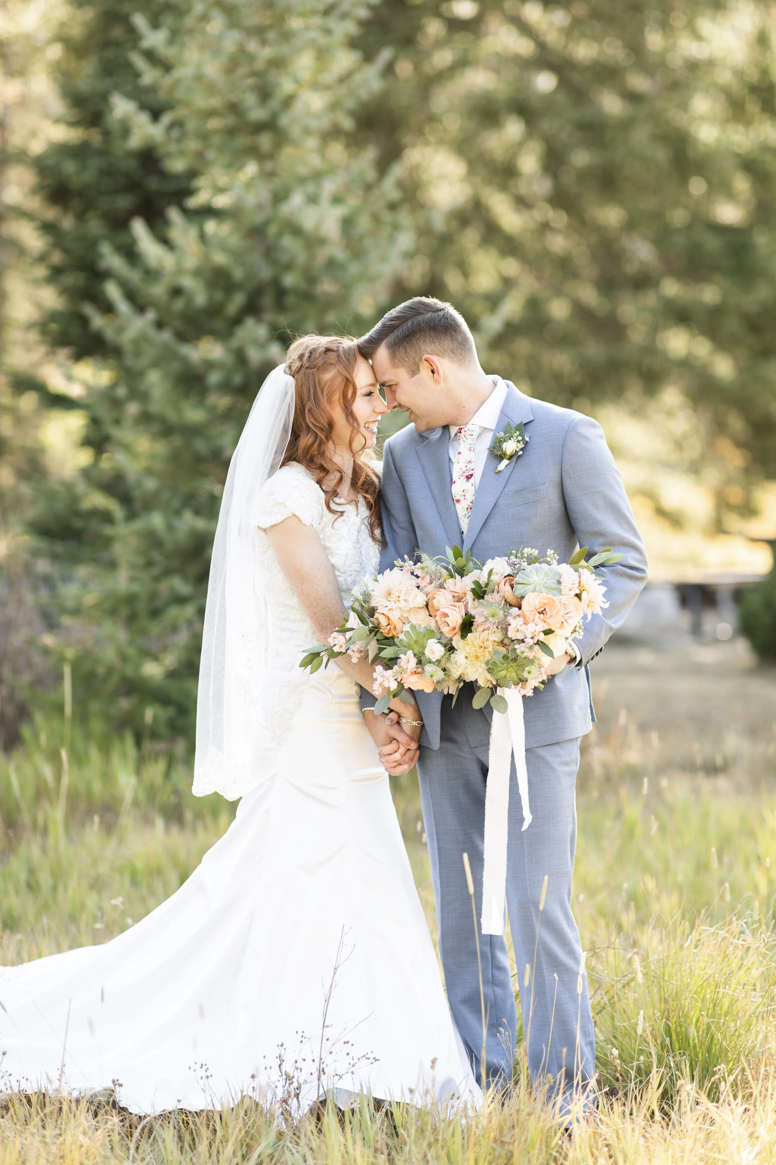  Bride and groom in love forehead to forehead pose inspiration holding hands silver lake big cottonwood canyon salt lake city utah oval shaped bouquet pink blooms red haired bride modest wedding gown inspiration large bouquet inspiration canyon brida