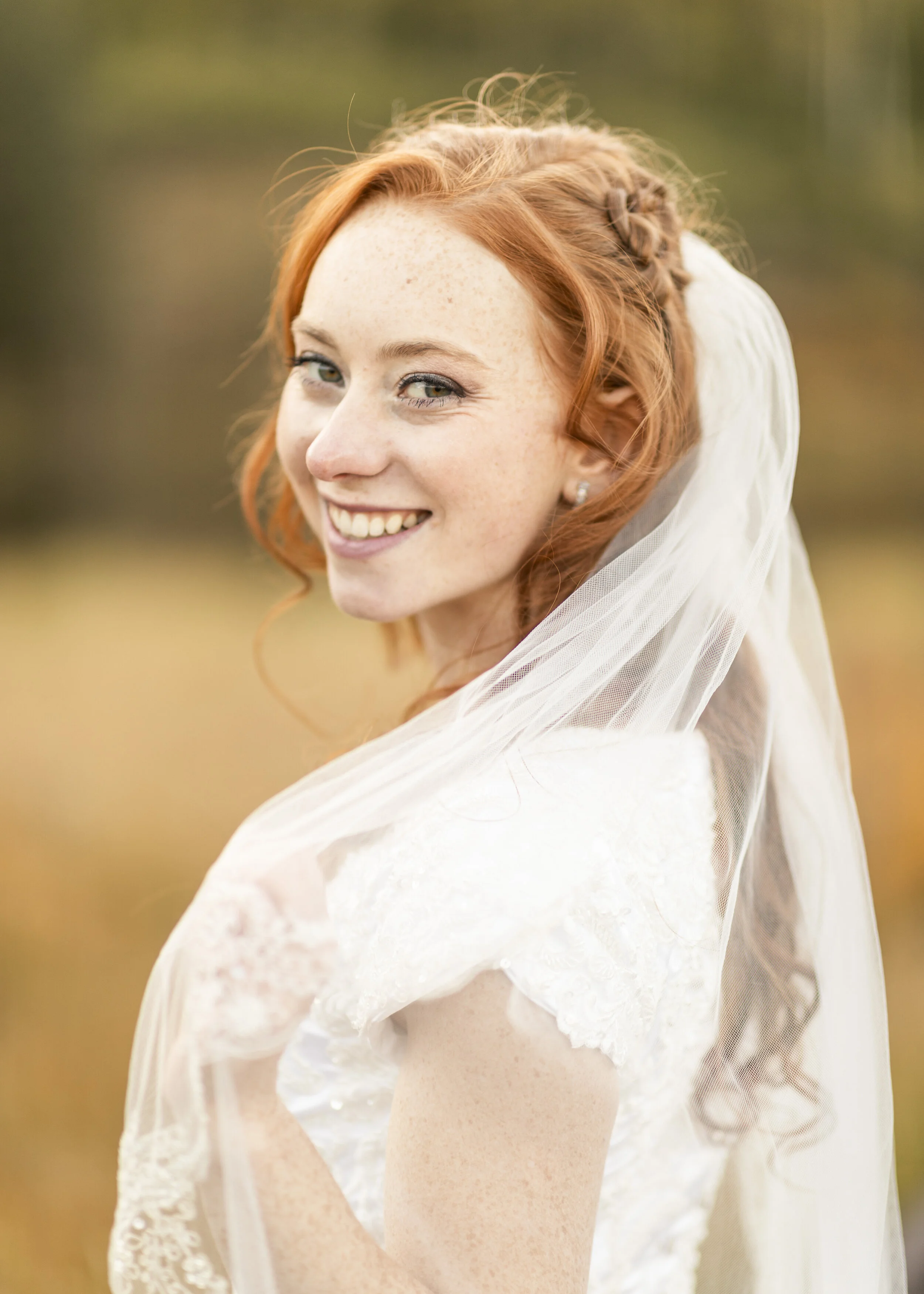  Beautiful bride holding veil bride headshot red hair inspiration white smile authentic smile short sleeve wedding gown veil shot ideas natural bride make up simple wedding day make up fair skin head shot bridals bride portrait outdoor wedding photo 