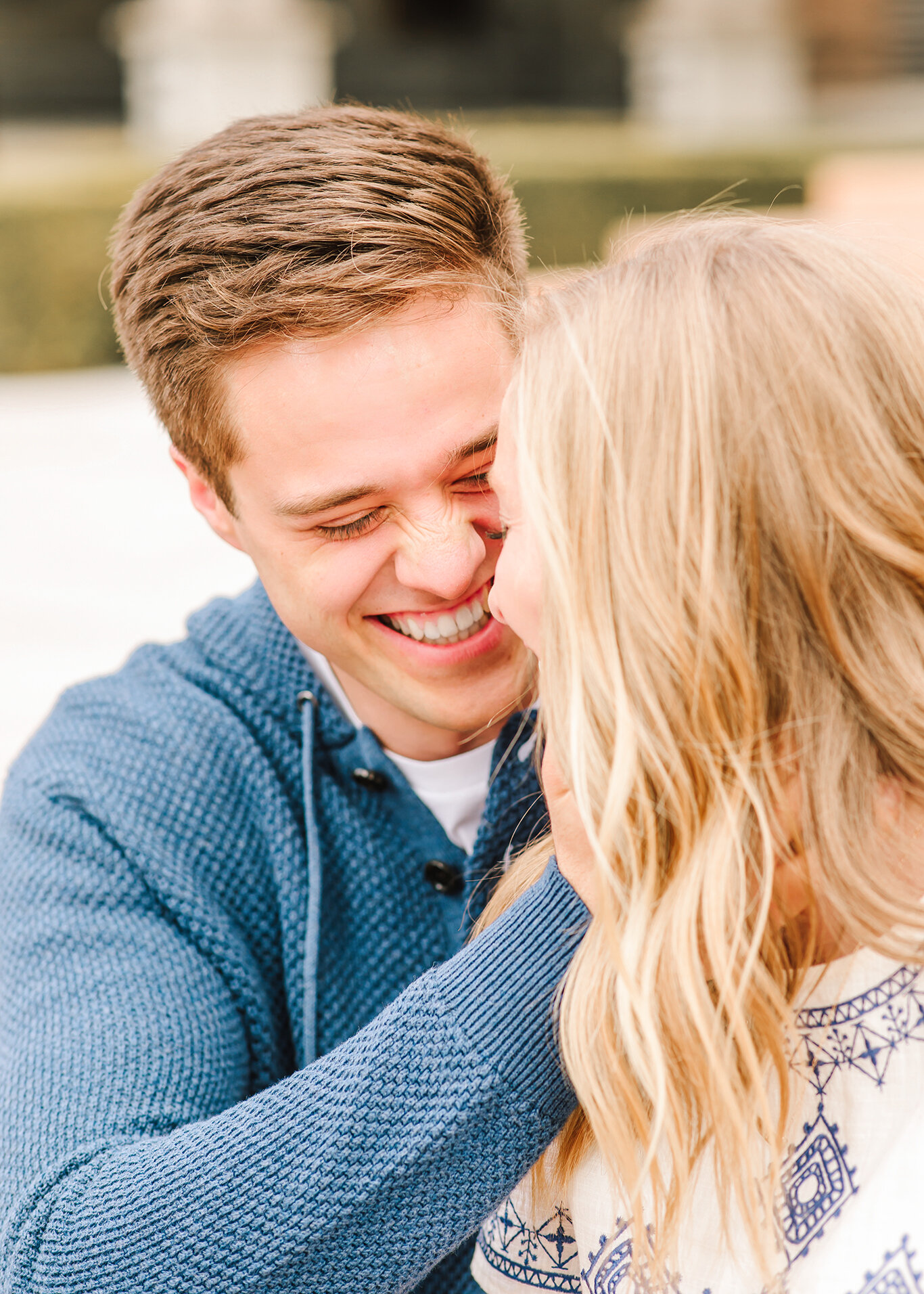  Downtown salt lake city photo session engagement session navy blue sweater navy blue thread detail loose hanging curls smiling at each other leaning in for a kiss salt lake city utah professional utah valley engagement photographer #downtownsaltlake