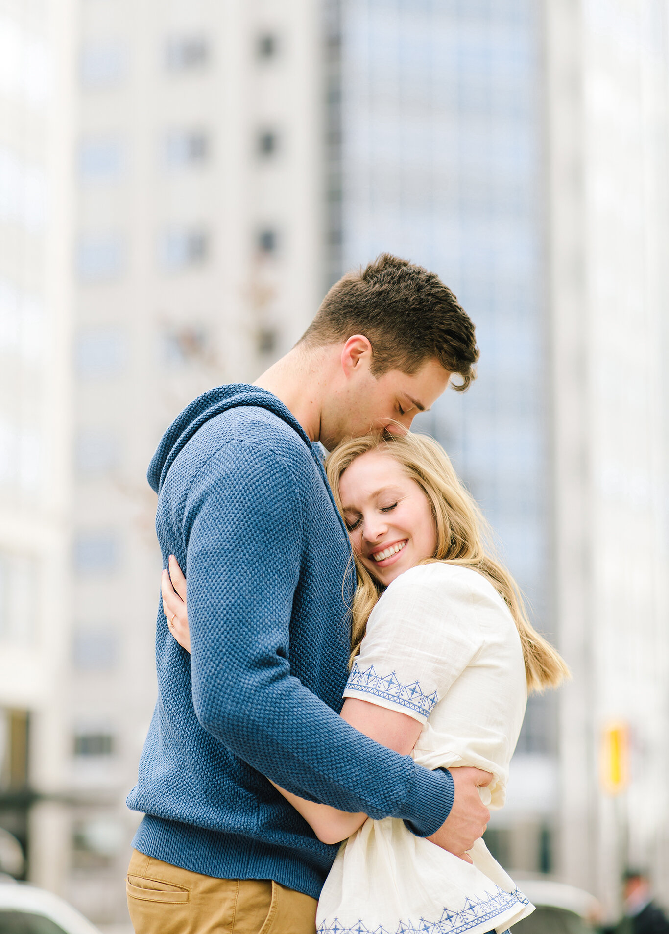  navy blue sweater navy blue detailed blouse loose hanging curls kiss on the head smiling downtown salt lake city background salt lake city utah professional utah valley engagement photographer #downtownsaltlakecity #engagements #utah #saltlakecity #