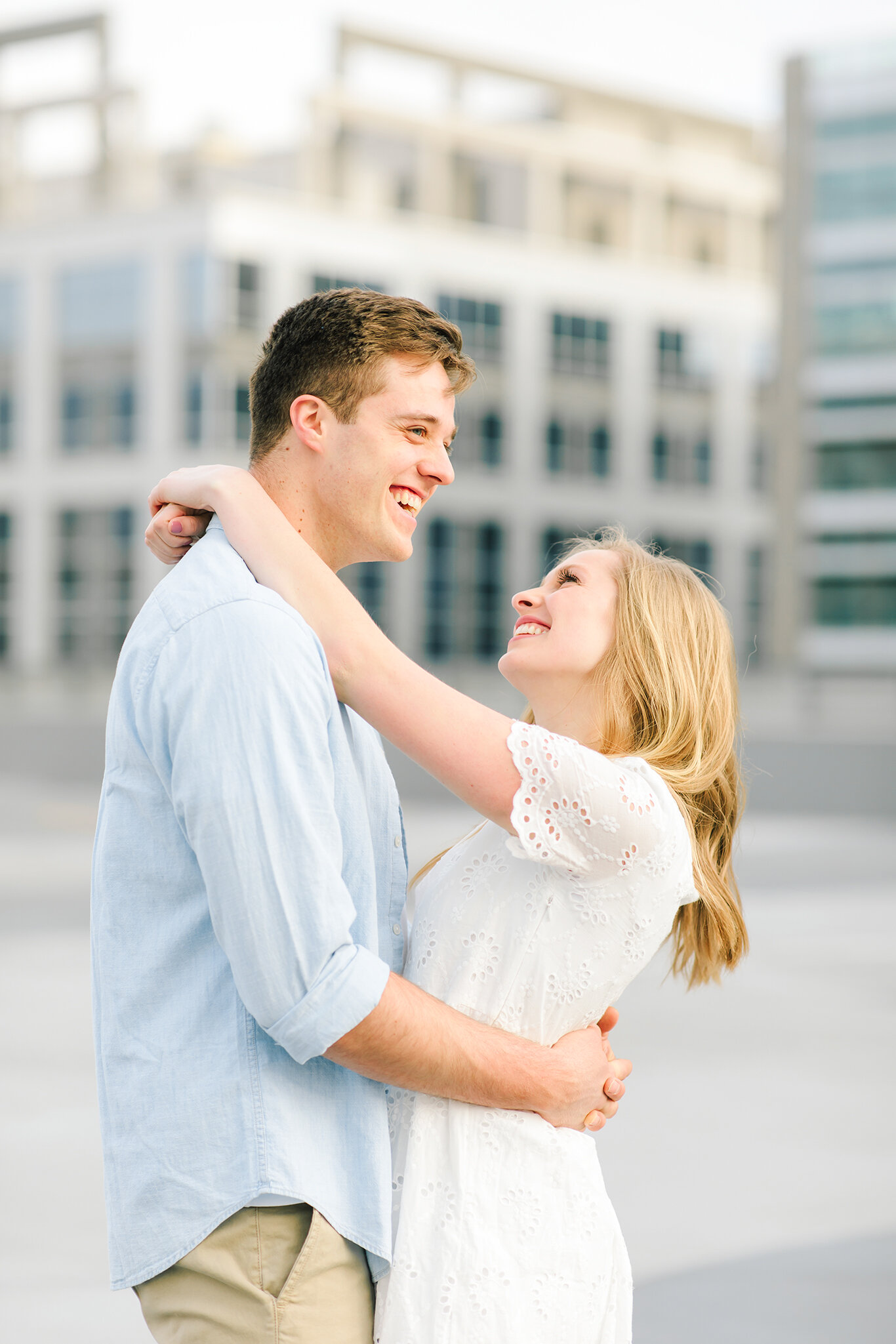  light blue collared shirt white lace short sleeve dress loose hanging curls downtown salt lake city engagement session roof top photo shoot salt lake city utah professional utah valley engagement photographer #downtownsaltlakecity #engagements #utah