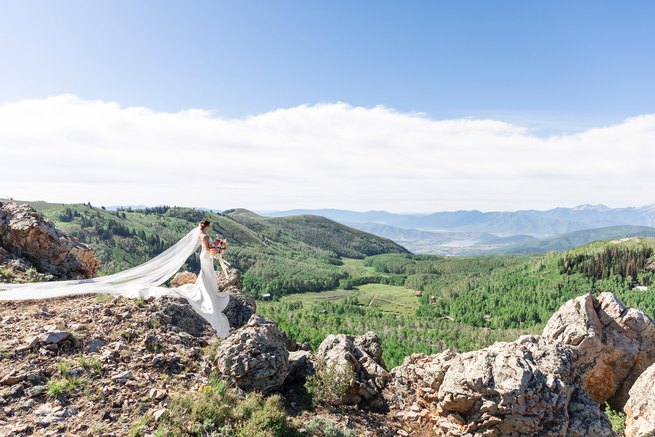  majestic summer wedding bridals shot by clarity lane photography in the utah mountains featuring a long bridal train. long draped bridal train mountain peak utah valley wedding photographer bridals pastel rose bridal bouquet green utah mountains loo