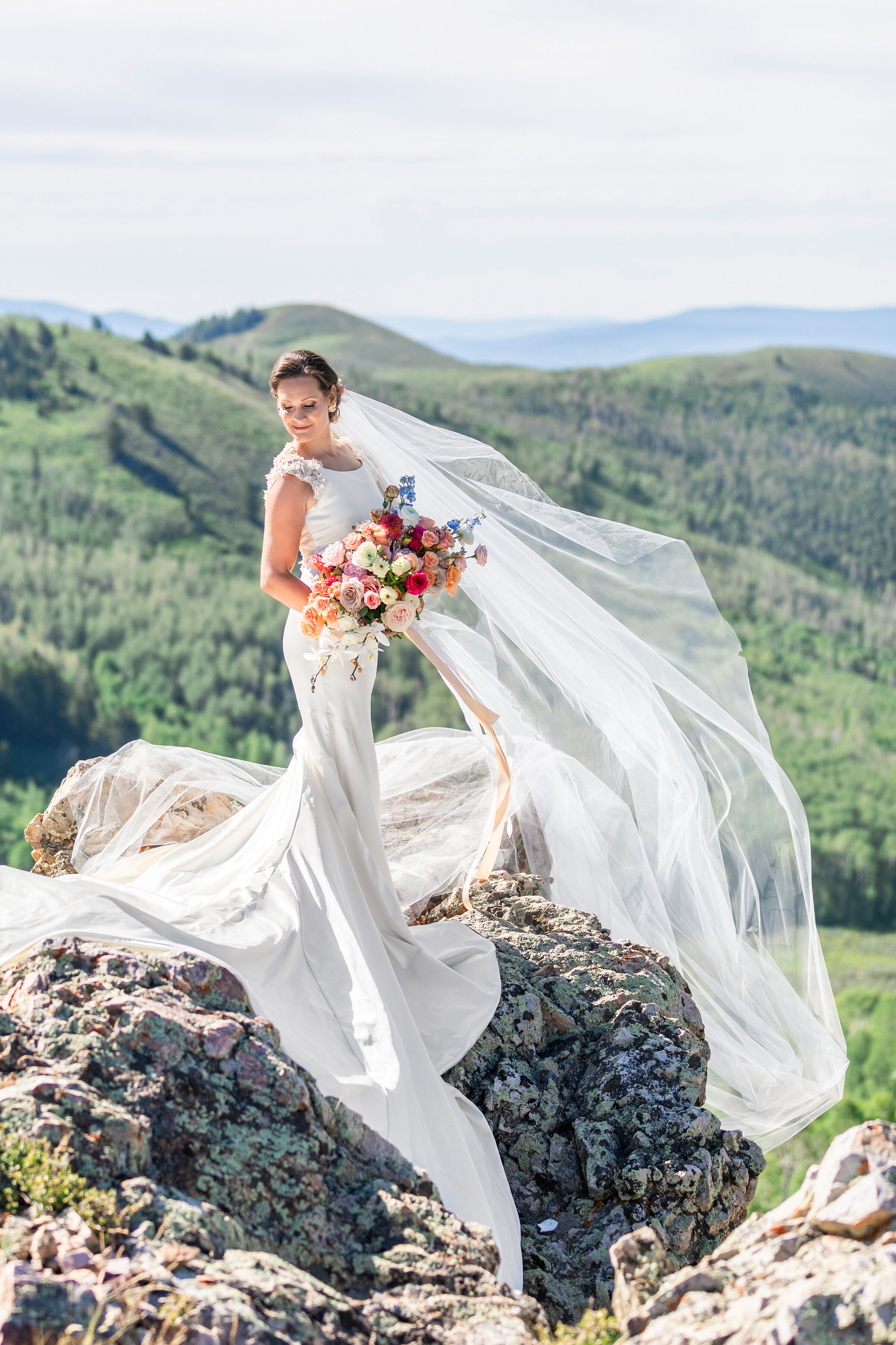  bridals shot by clarity lane photography located in lush green utah valley mountains. utah valley wedding photographer long windy bridal veil pastel rose bridal bouquet windy veil windy pink bouquet ribbon floral accent wedding dress wedding updo mo