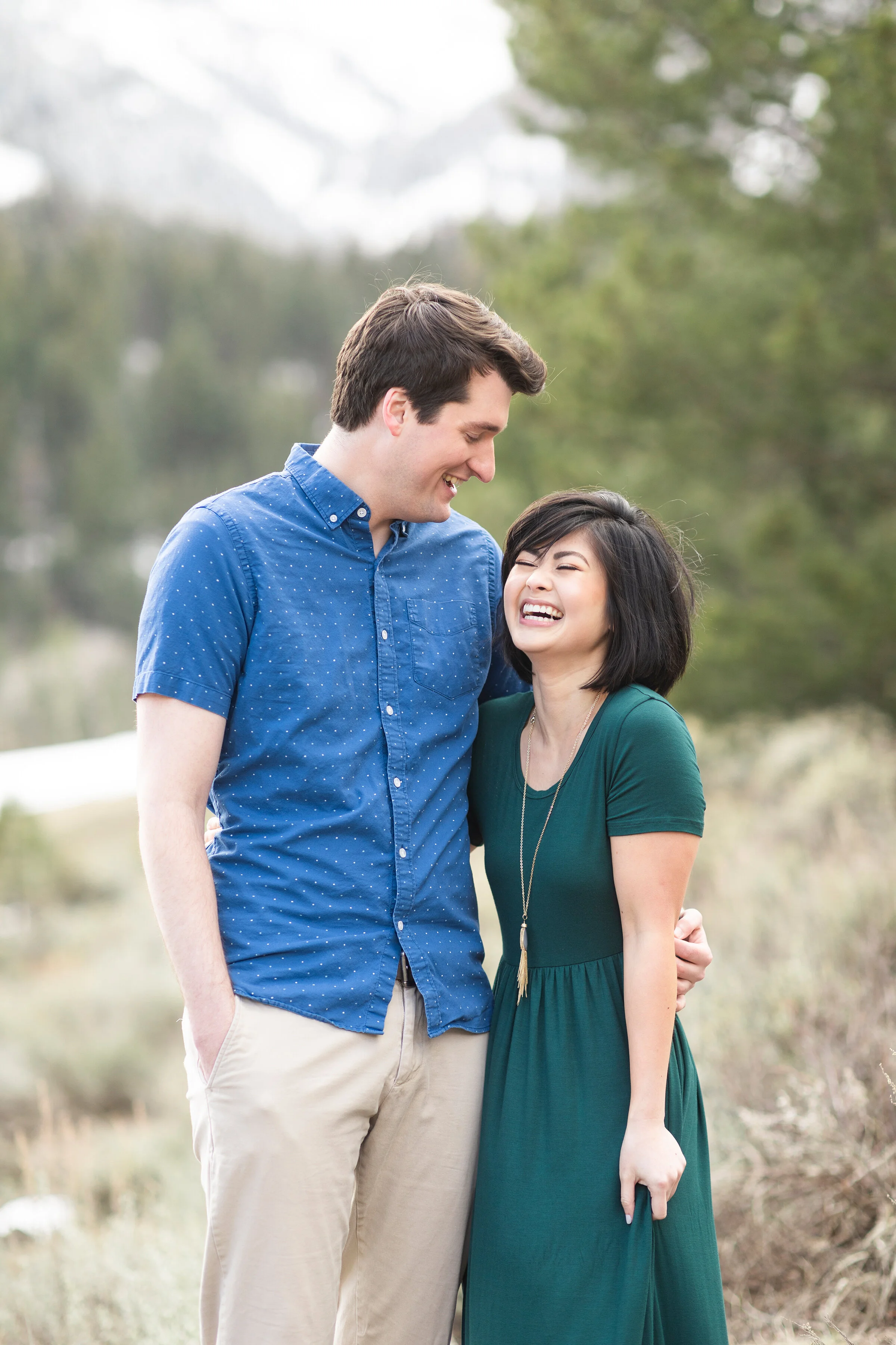  A newlywed couple laugh together in the mountains in a beautiful out door photo shoot. Clarity Lane couple attire inspiration semi formal couple attire early  winter couple attire inspiration photo shoot hairstyle for women photo shoot attire for me