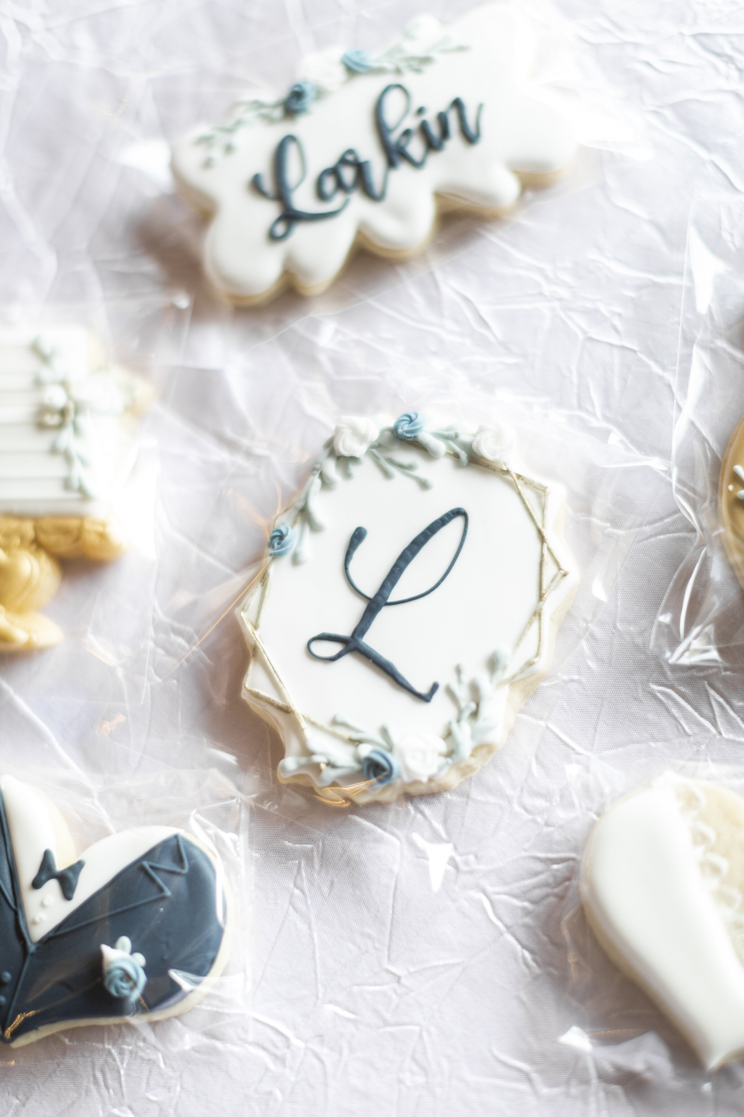  Utah County’s Clarity Lane Photography captures wedding day reception details highlighting personalized sugar cookies. royal icing sugar cookies, custom wedding reception sugar cookies, white and blue sugar cookies, last name initial wedding cookies