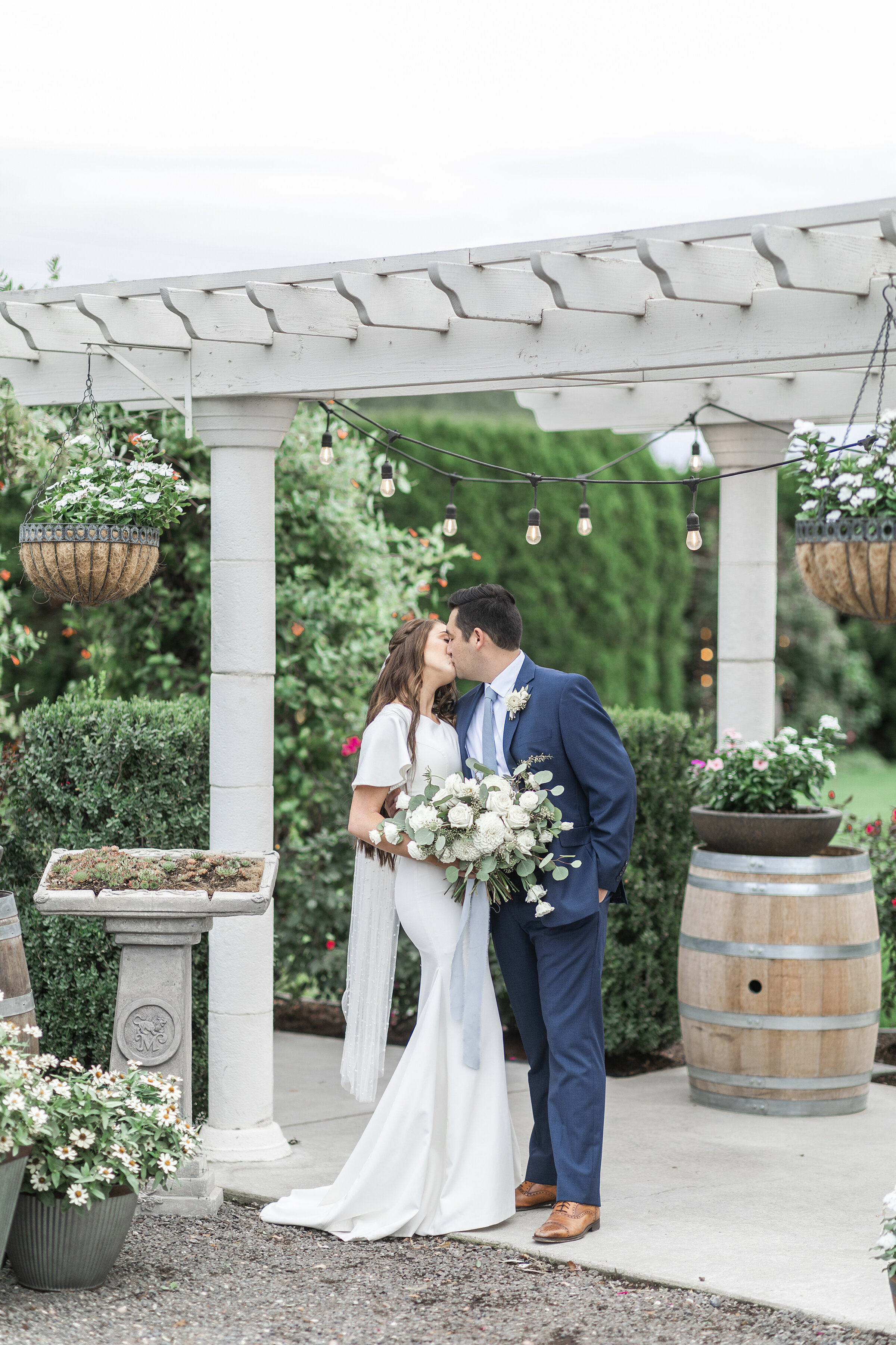  Posed beneath a white gazebo, Clarity Lane Photography captures this newlywed Salt Lake City, Utah couple. calf length wedding veil, flutter sleeve wedding dress, white wedding bouquet, white gazebo, navy wedding suit, leather brown wedding shoes, p