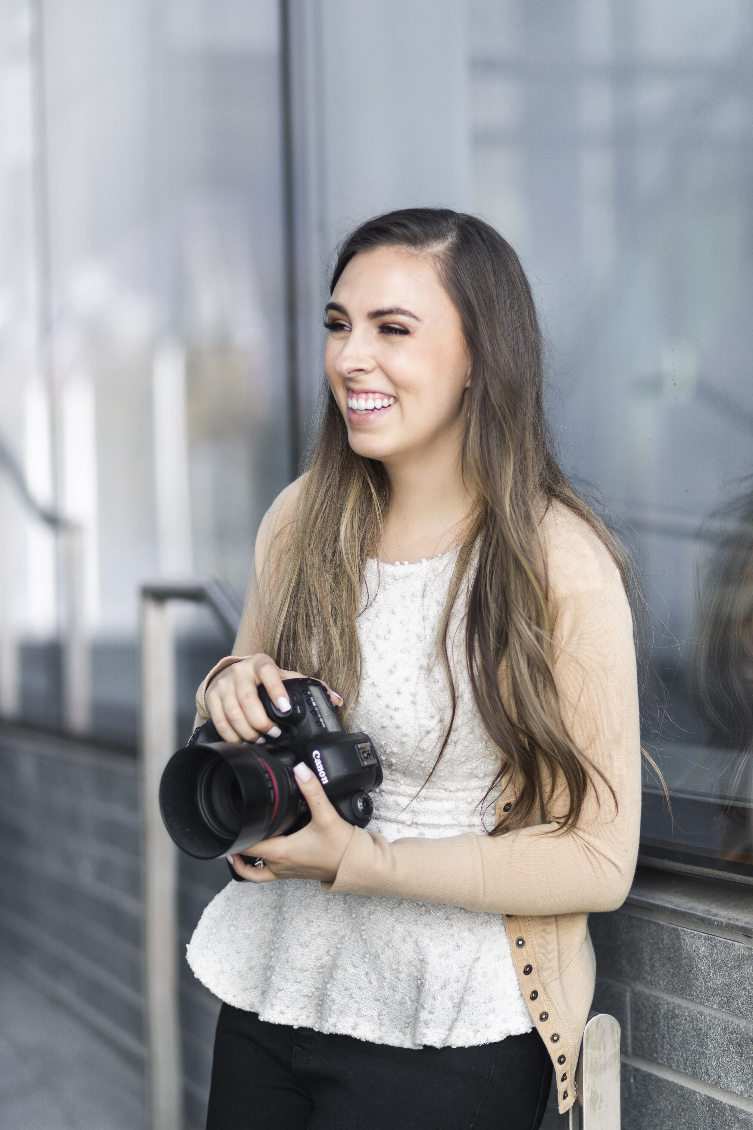  The owner of Clarity Lane Photography poses for a styled branding photoshoot in Provo, Utah. professional utah county photographer, professional photographer dslr canon camera, white acrylic nails, loose curled brown balayage hair, brown smokey eye,