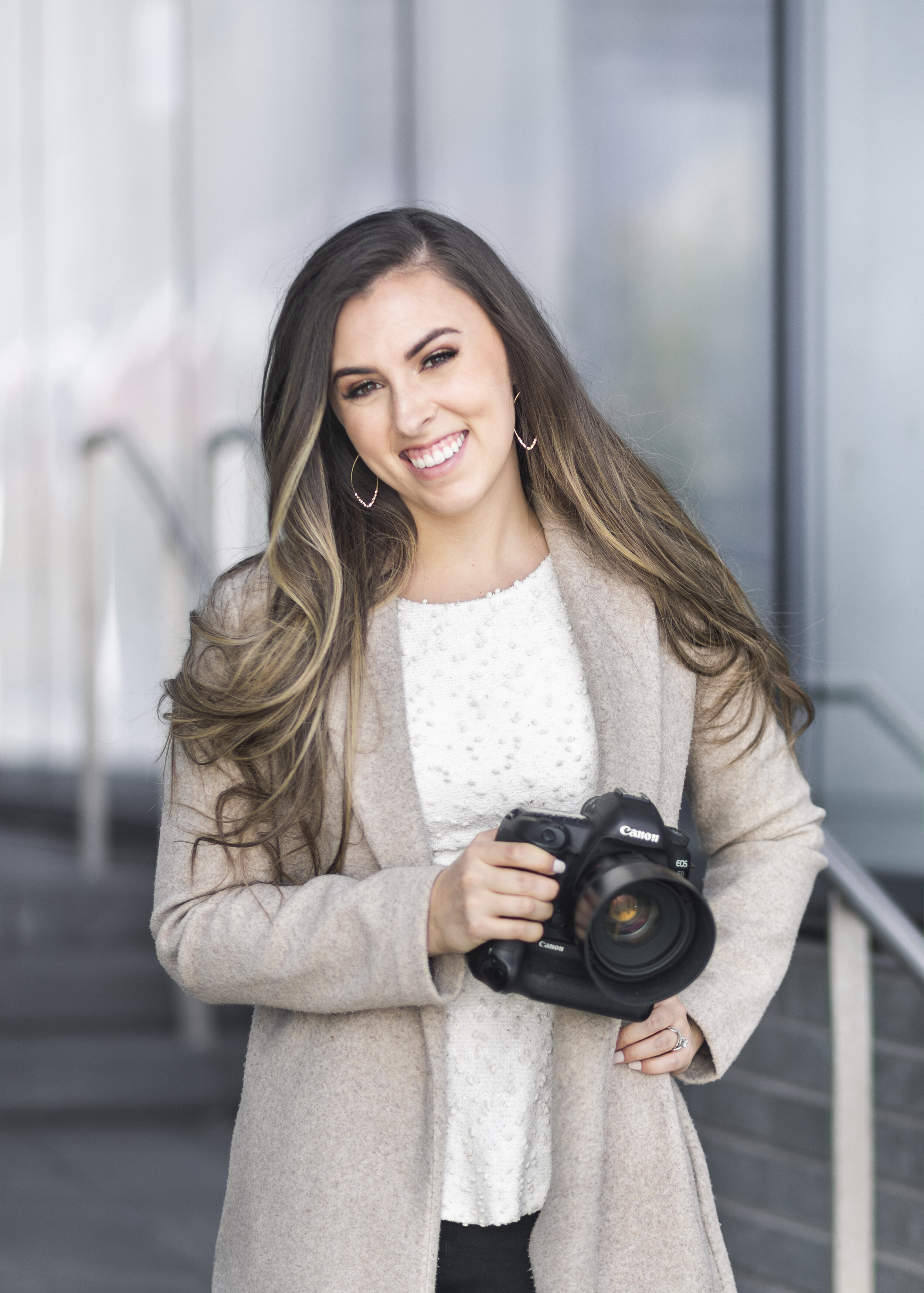  The owner of Utah County’s Clarity Lane Photography poses with her Canon DSLR camera in Salt Lake City, Utah. loose curled long balayage hair, open long khaki womens trench coat cardigan,  canon dslr camera, utah valley professional photographer #Sa