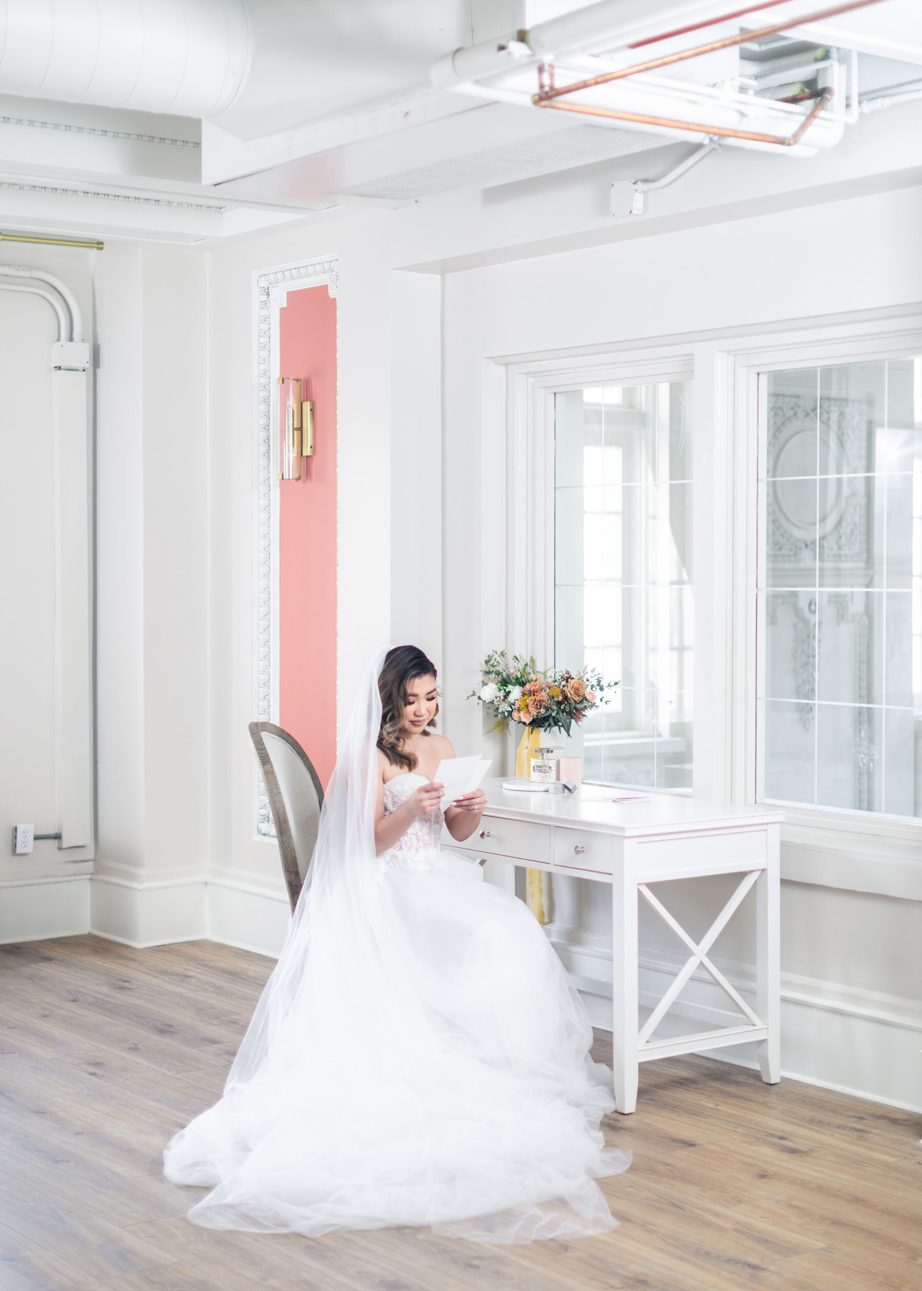  On this bride's wedding morning in Salt Lake City, UT, Clarity Lane captures this bride sitting at a white makeup vanity, reading a letter from her groom. wedding morning letters bride opening groom's gift Salt Lake City wedding photographer #Clarit