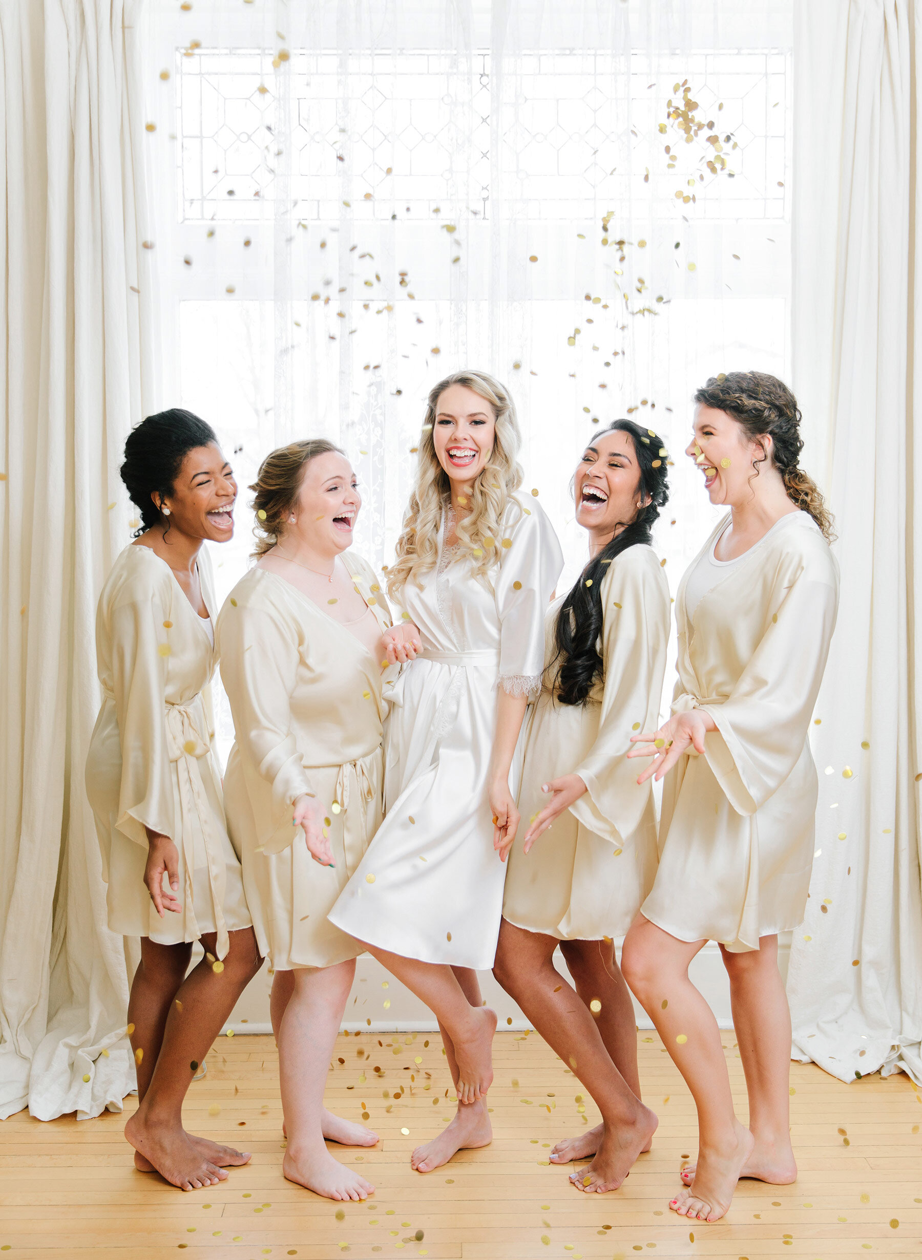  Smiling and laughing with her bridesmaids in their ivory silk wedding robes, Salt Lake City, UT photographer, Clarity Lane captures this bride tossing confetti on her wedding morning. wedding morning bride with bridesmaids wedding party silk robes S