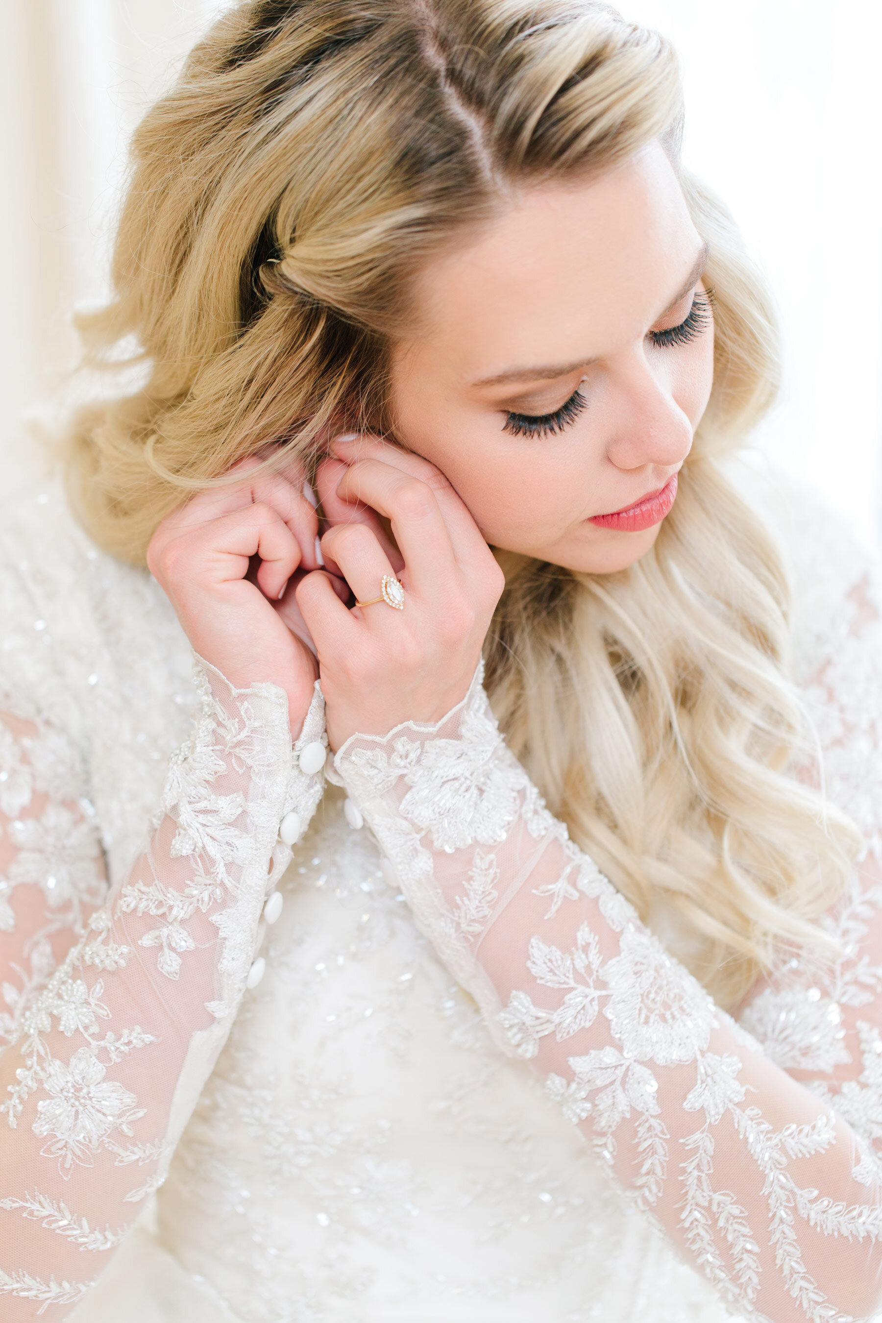  On this bride's wedding morning, Utah County wedding photographer, Clarity Lane captures up-close details of this bride putting in earrings. brides earrings long translucent lace wedding sleeve long blonde loose curled wedding hair women's false wed