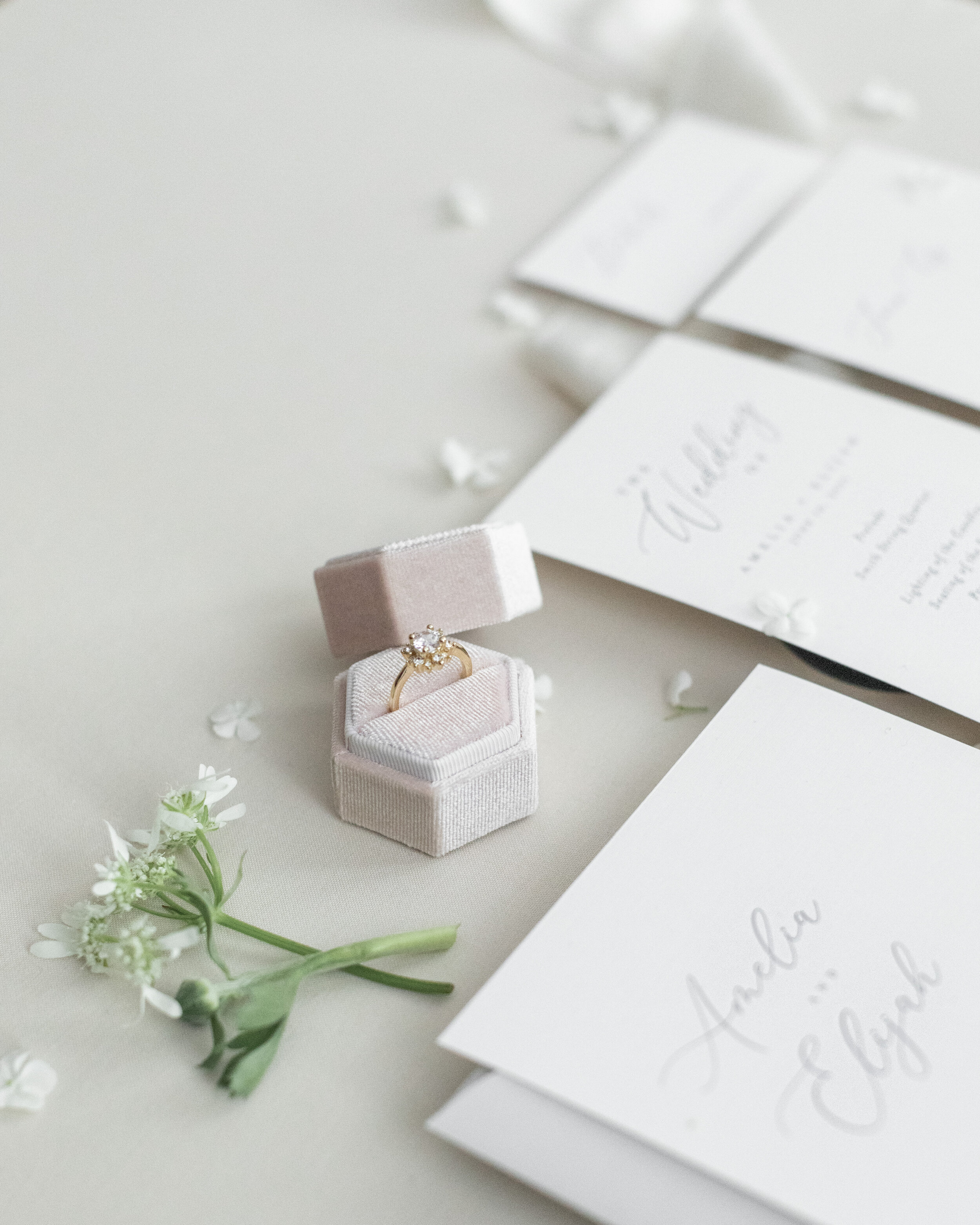  A flat lay photograph of wedding invites and gold wedding ring in a pink box by Clarity Lane Photography during a photography mastermind in Cache Valley. wedding ring flat-lay inspiration #claritylanephotography #claritylaneweddings #claritylanework