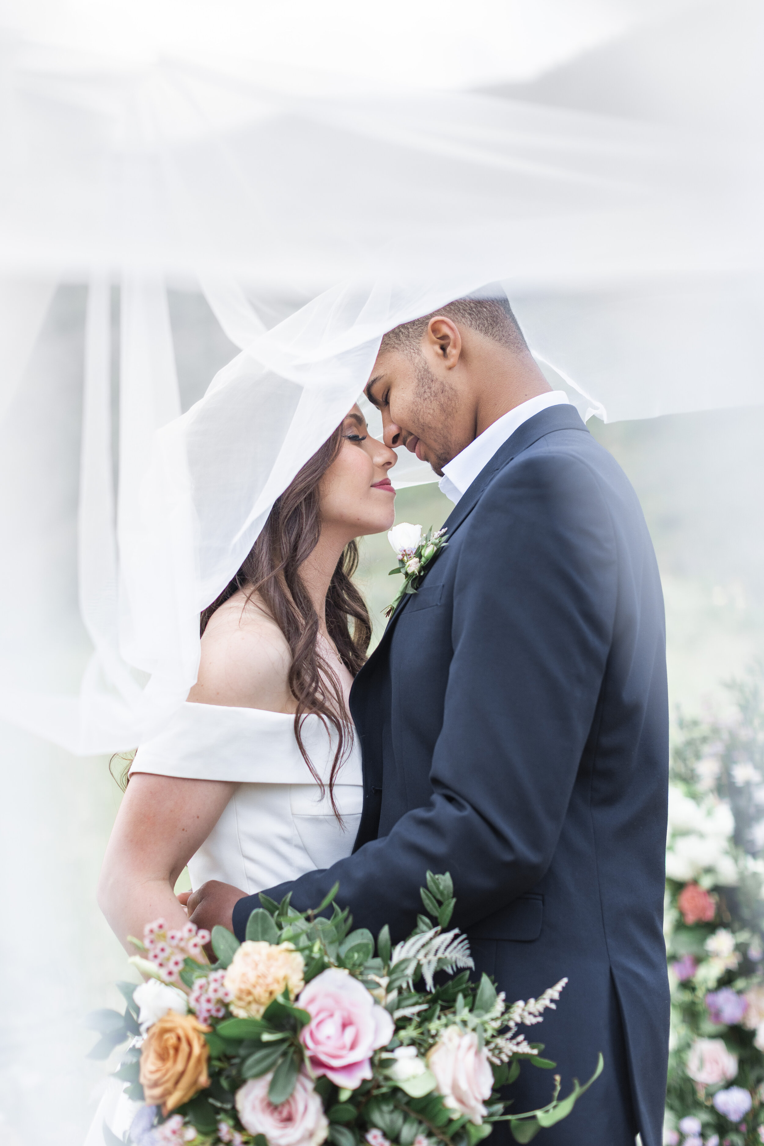  A couple going in for a kiss underneath a veil during a photography Clarity Lane Photography showing photographers how to captures wedding day photos in Cache Valley Utah. intimate veil photo Utah wedding photographer professionals #claritylanephoto