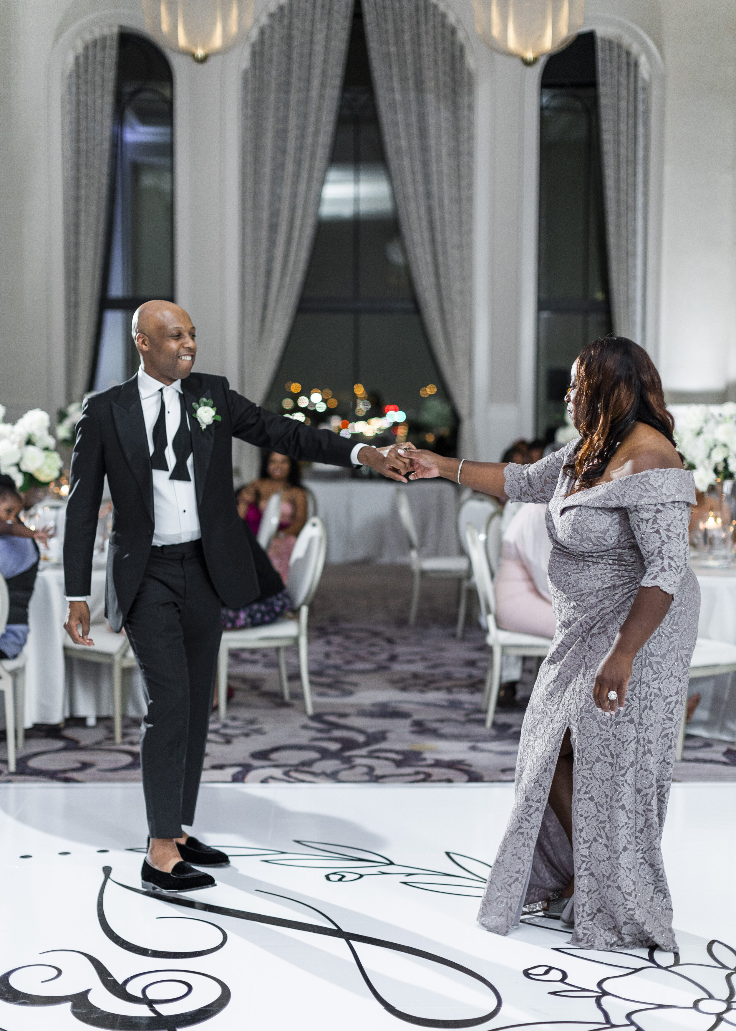  The mother of the groom and the groom dance for guests at a beautiful Dallas, TX wedding. Wedding reception photos dance floor inspiration mother son dance mother of the groom outfit ideas mother of the son dress elegant wedding photographer in DFW 