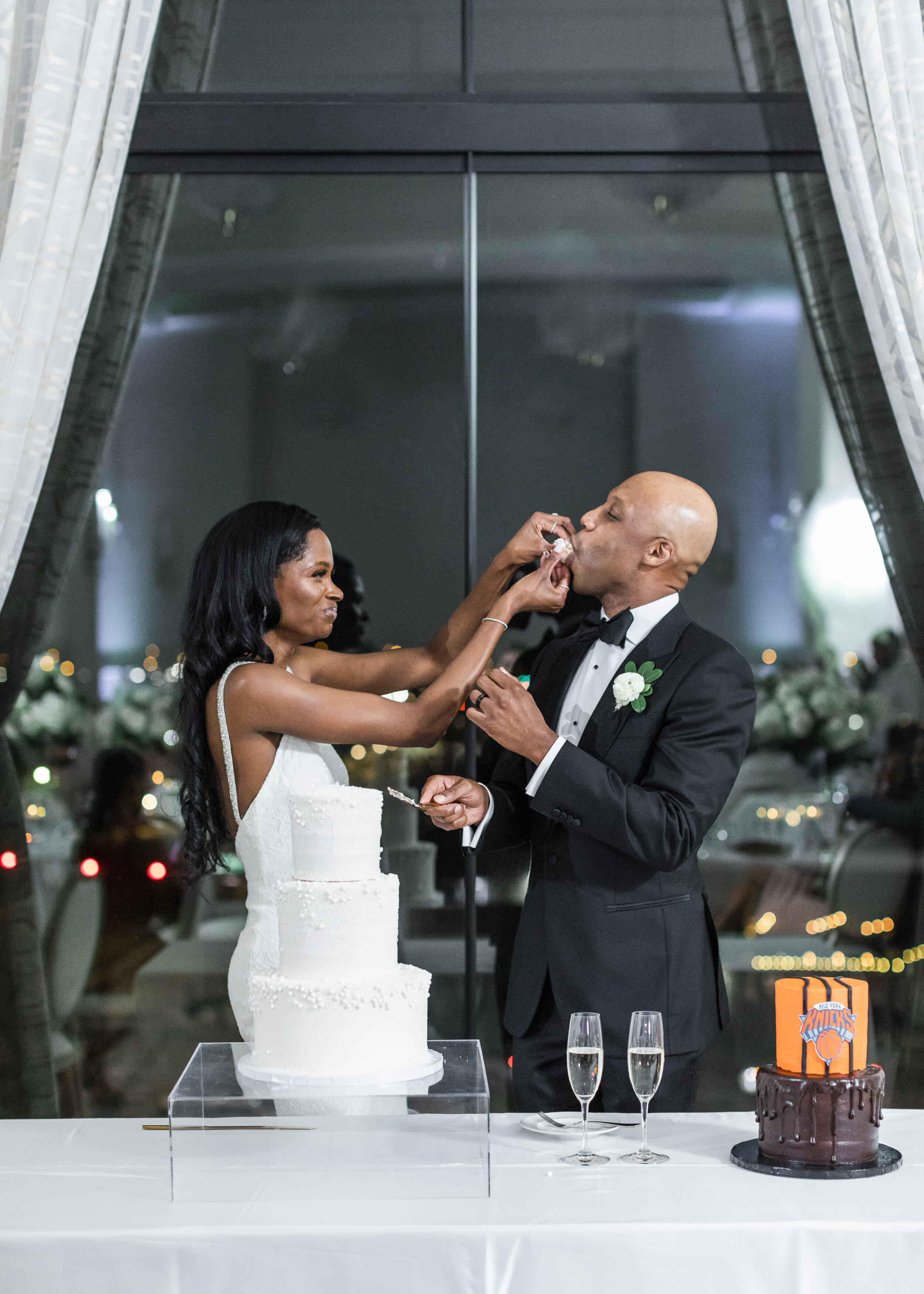  A bride and groom try their wedding cake after the cake cutting. Black and white wedding inspriation white wedding cake wedding cake ideas classy wedding cake elegant wedding details indoor wedding venue hotel vin provo arlington texas photographer 