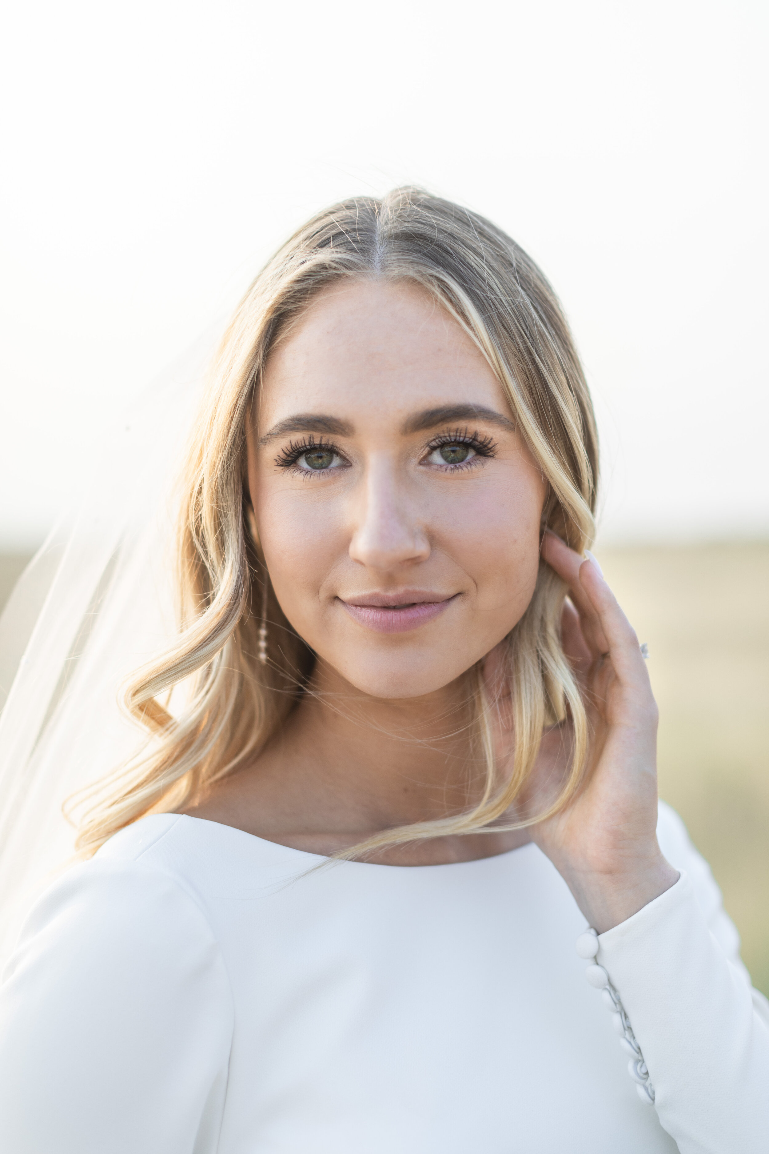  A blonde woman in a wedding dress smiles in a classy wedding gown with hair parted down the middle in Salt Lake City Utah by Savanna Richardson Photography. bridal portrait classy wedding dress #savannarichardsonphotography #savannaarichardsonweddin
