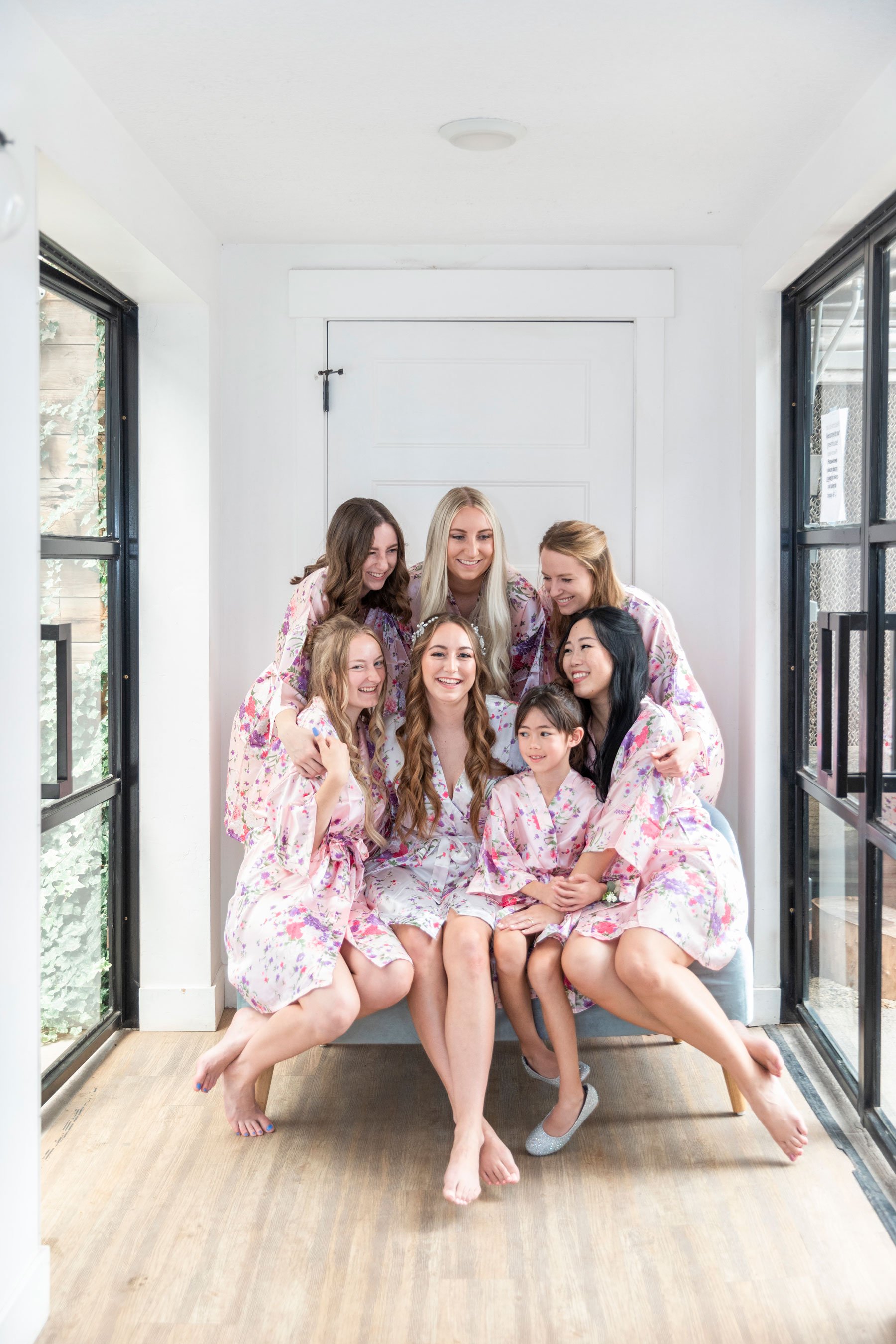  Bride with her cute bridesmaids in matching pink floral robes getting ready for a wedding by Savanna Richardson Photography, a professional Orem wedding photographer. bride with bridesmaids floral matching robes pink bridesmaids robes #savannarichar