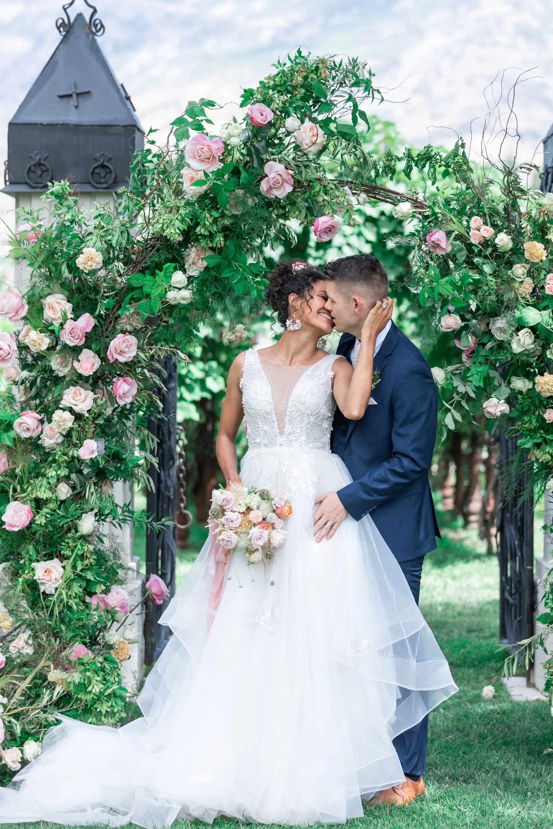  Savanna Richardson Photography gives good advice on how to look your best in your wedding photos capturing a couple kissing under a floral arch. floral arch wedding kissing pictures spring wedding goals wedding day reminders #savannarichardsonphotog