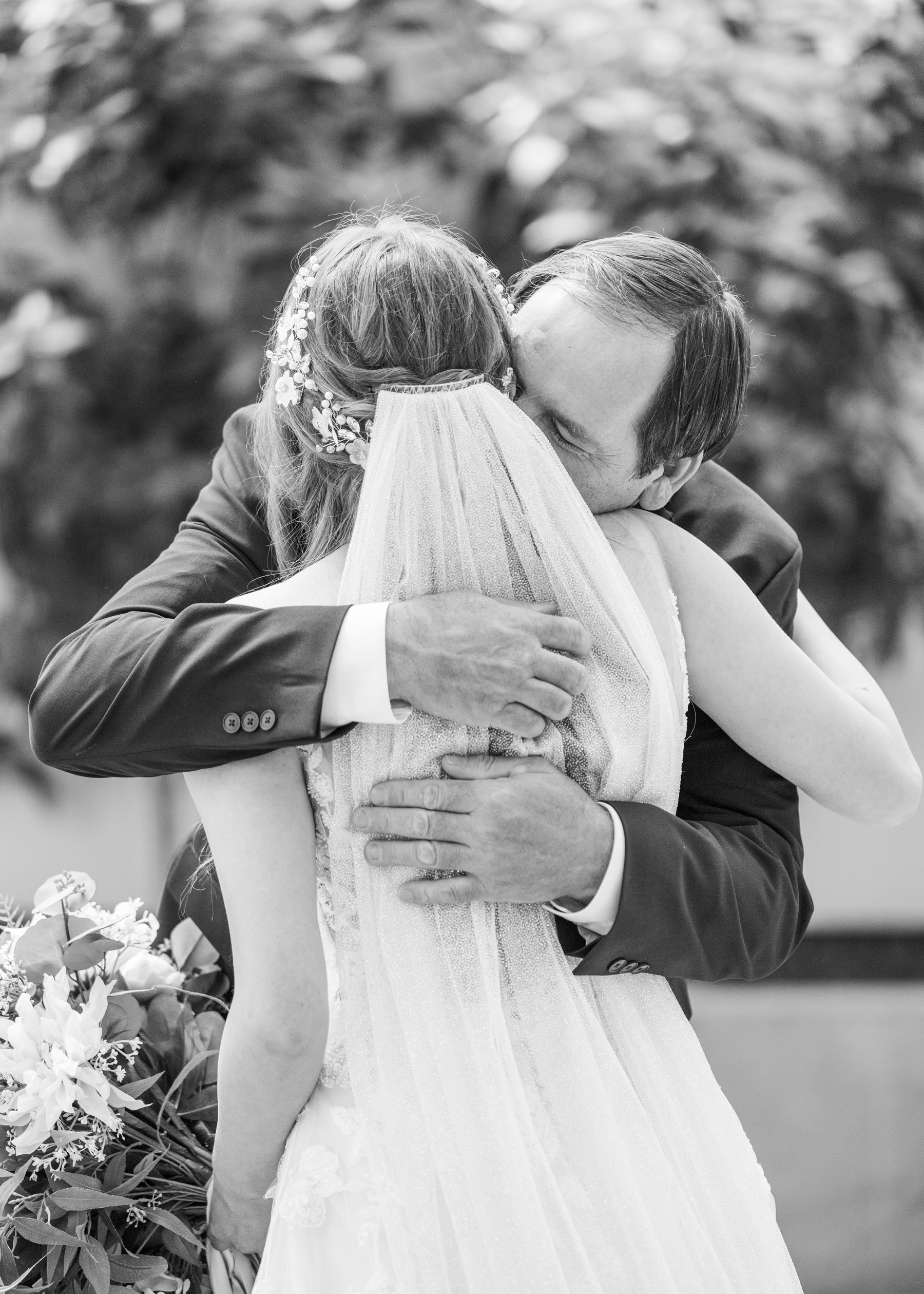  A black and white portrait of a father holding his bride in his arms before she walks down the aisle in Orem, Utah by wedding photographer Savanna Richardson Photography. father of the bride daddy daughter wedding picture #savannarichardsonphotograp
