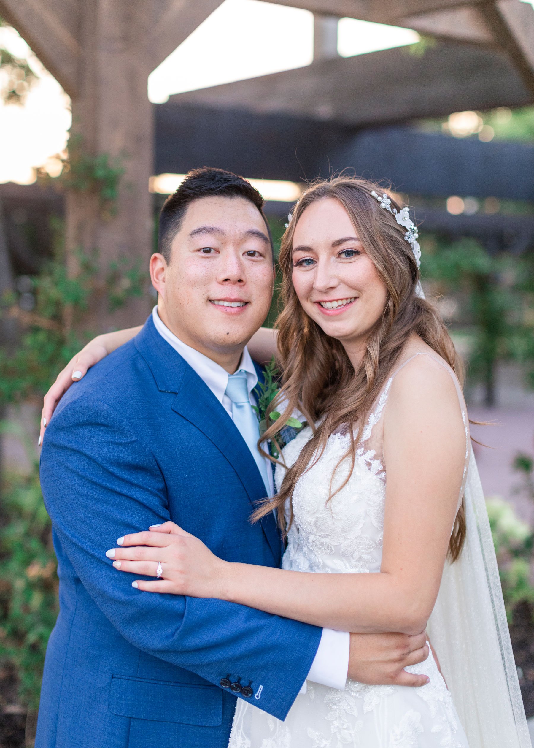  Bride and groom portrait featuring a man with blue suit and tie and a strapless wedding gown at Shade and Home Garden Center in Orem by Savanna Richardson Photography. bride and groom portraits happy couple newlyweds tied the knot #savannarichardson
