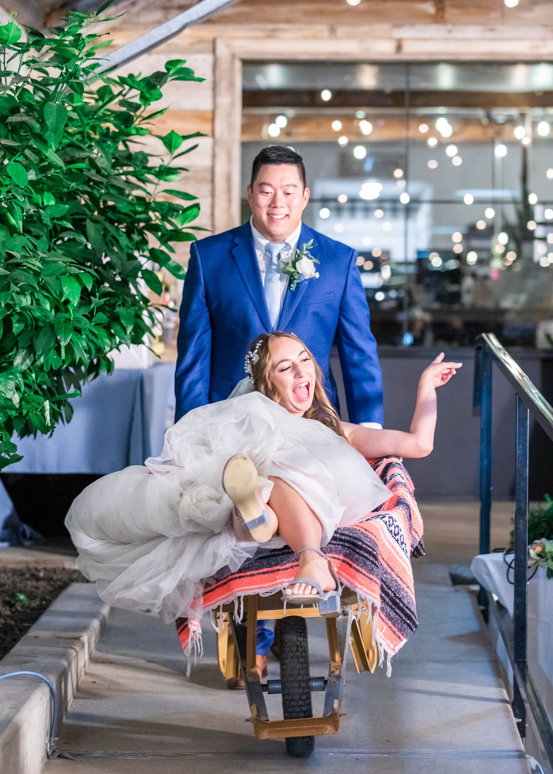  Darling fun picture of the groom pushing the bride in a wheelbarrow as she sits on a Mexican blanket and parties by Savanna Richardson Photography. fun wedding pictures wheelbarrow wedding pictures spunky wedding portraits #savannarichardsonphotogra