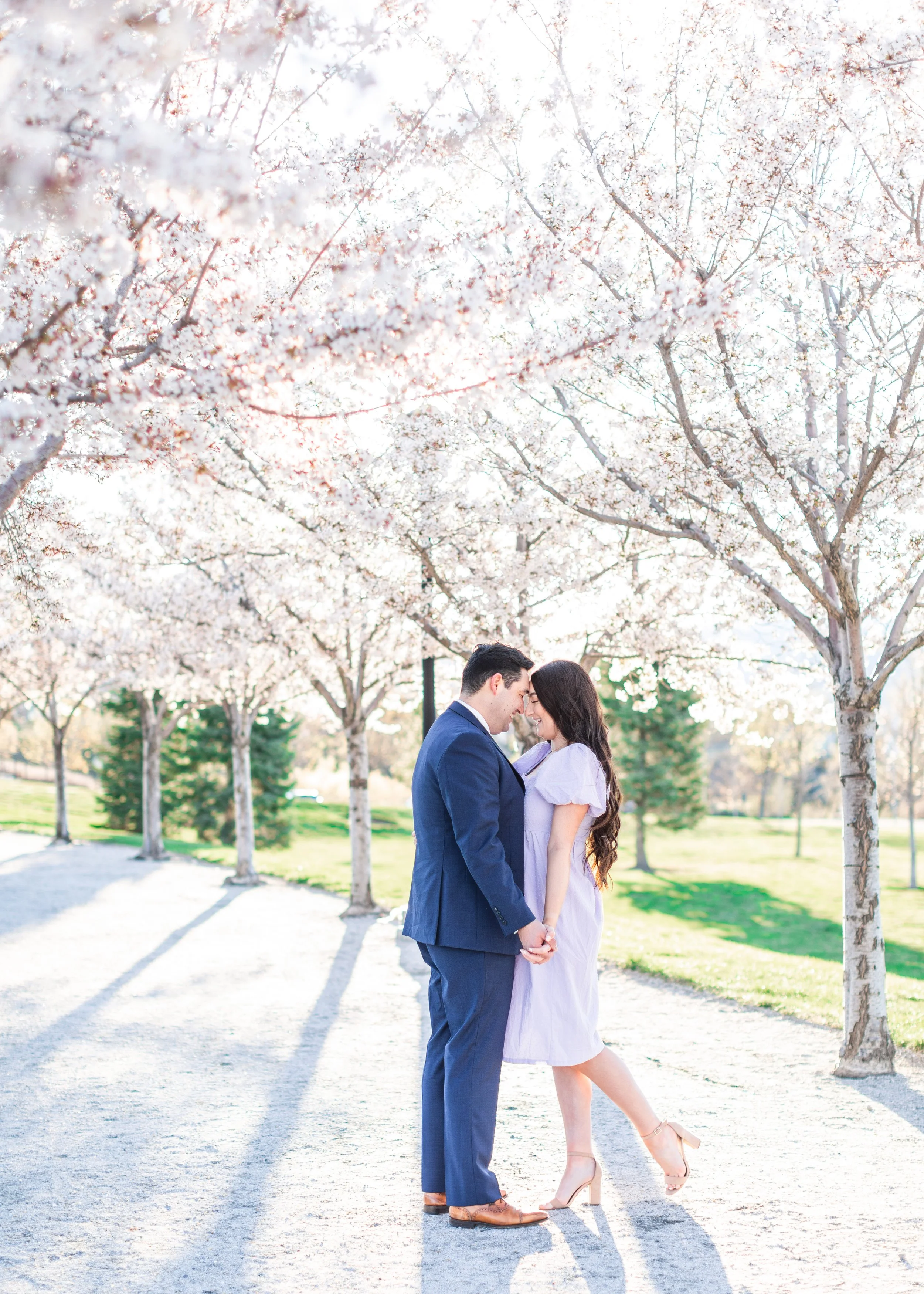  Savanna Richardson Photography captures engagement photos underneath white blossom trees at the Utah State Capitol. spring blossom engagement photos #savannarichardsonphotography #utahphotographers #slcweddings #utahcountyweddingphotographer 