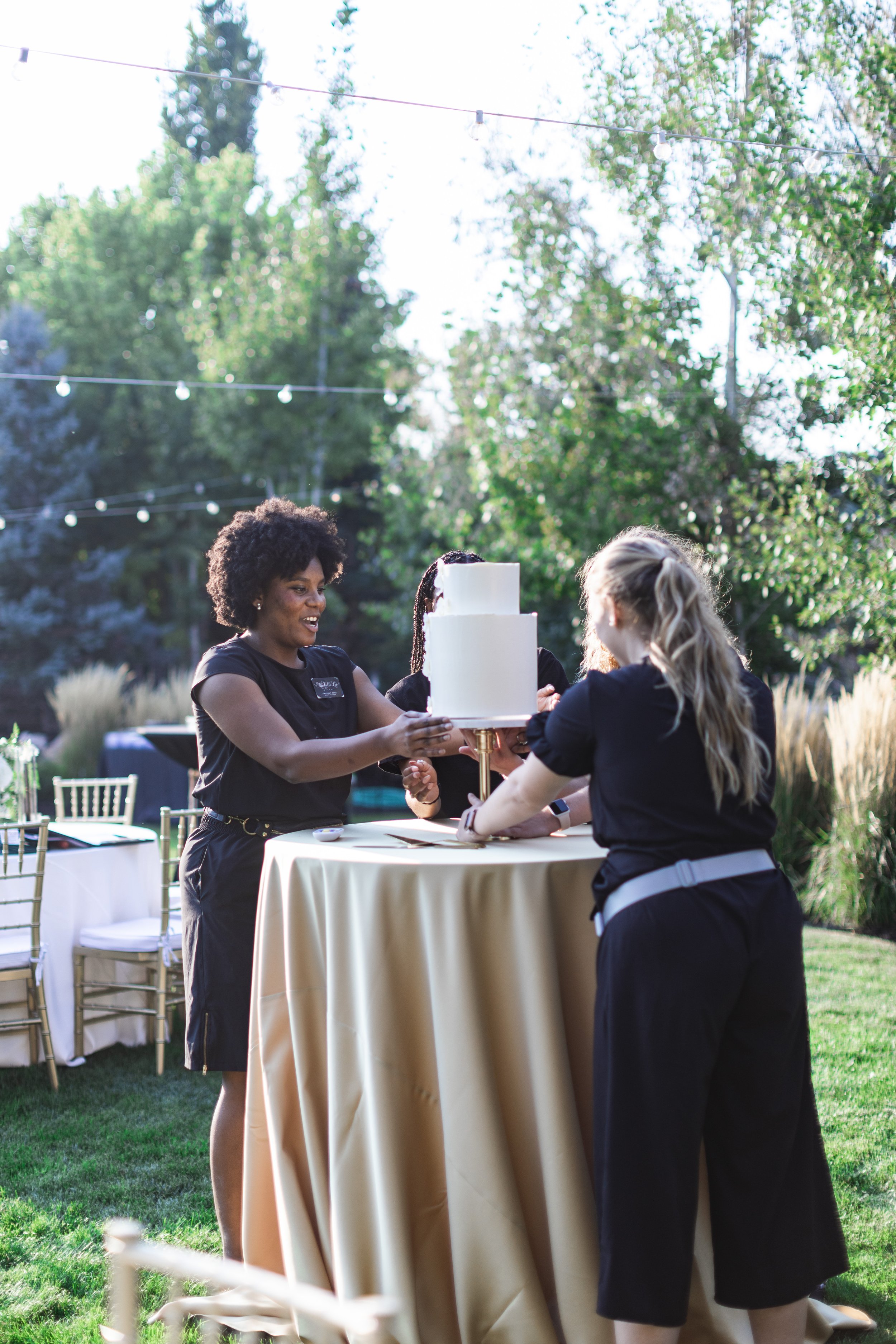  A wedding planner sets up cake with the cake decorator by Savanna Richardson Photography. wedding planners smooth wedding details #savannarichardsonphotography #weddingplannervsvenuecooridnator #weddingphotographer #weddingphotographersUtah 