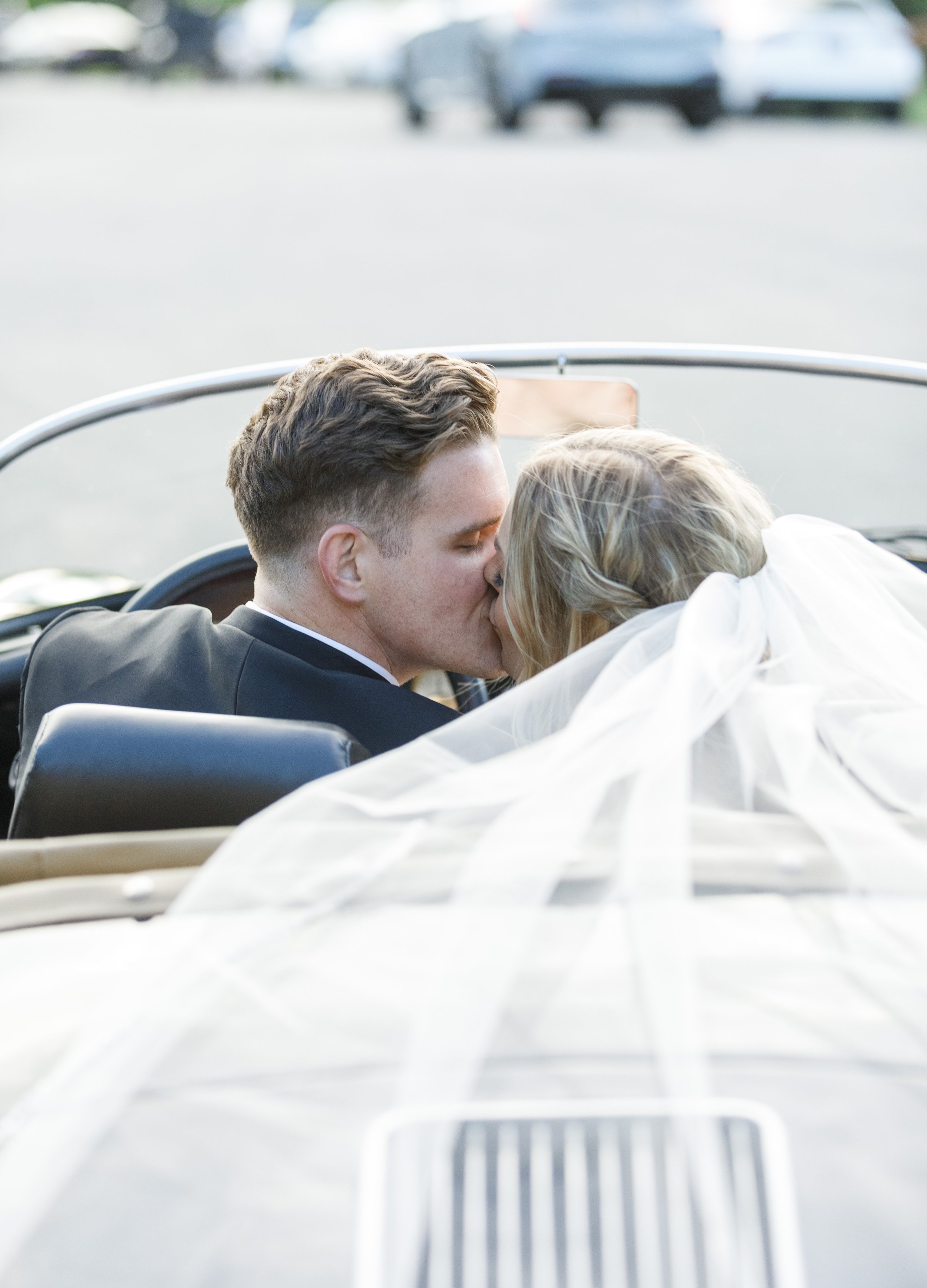  The newlyweds share a kiss in a classic Porsche with the bride’s veil flowing behind them. #tonygrove #cachevalley #utahbride #ldstemplewedding #savannarichardsonphotography #utahweddingphotographer #summerwedding #outdoorreception #weddingveilshots