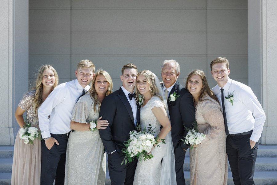  Family portrait of the bride and groom surrounded by the bride’s immediate family members. #savannarichardsonphotography #ldstemplewedding #cachevalley #brideandgroom #weddingportraits #sparklywedding #modestweddingguestoutfits #modestweddingdress 