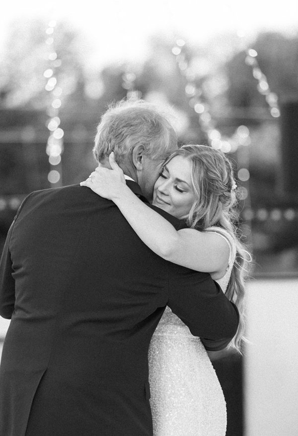  Black and white photo of a blonde bride hugging her dad during the father daughter dance at her wedding reception in Tony Grove. #savannarichardsonphotography #tonygrove #cachevalley #summerwedding #outdoorweddingreception #fatherdaughterdance #brid