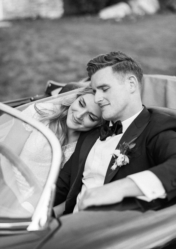  Black and white photo of the bride and groom snuggling in the front seat of a classic Porsche after their wedding ceremony. #savannarichardsonphotography #classiccars #weddingexitideas #newlywedpose #cachevalley #tonygrovewedding #weddingphotographe