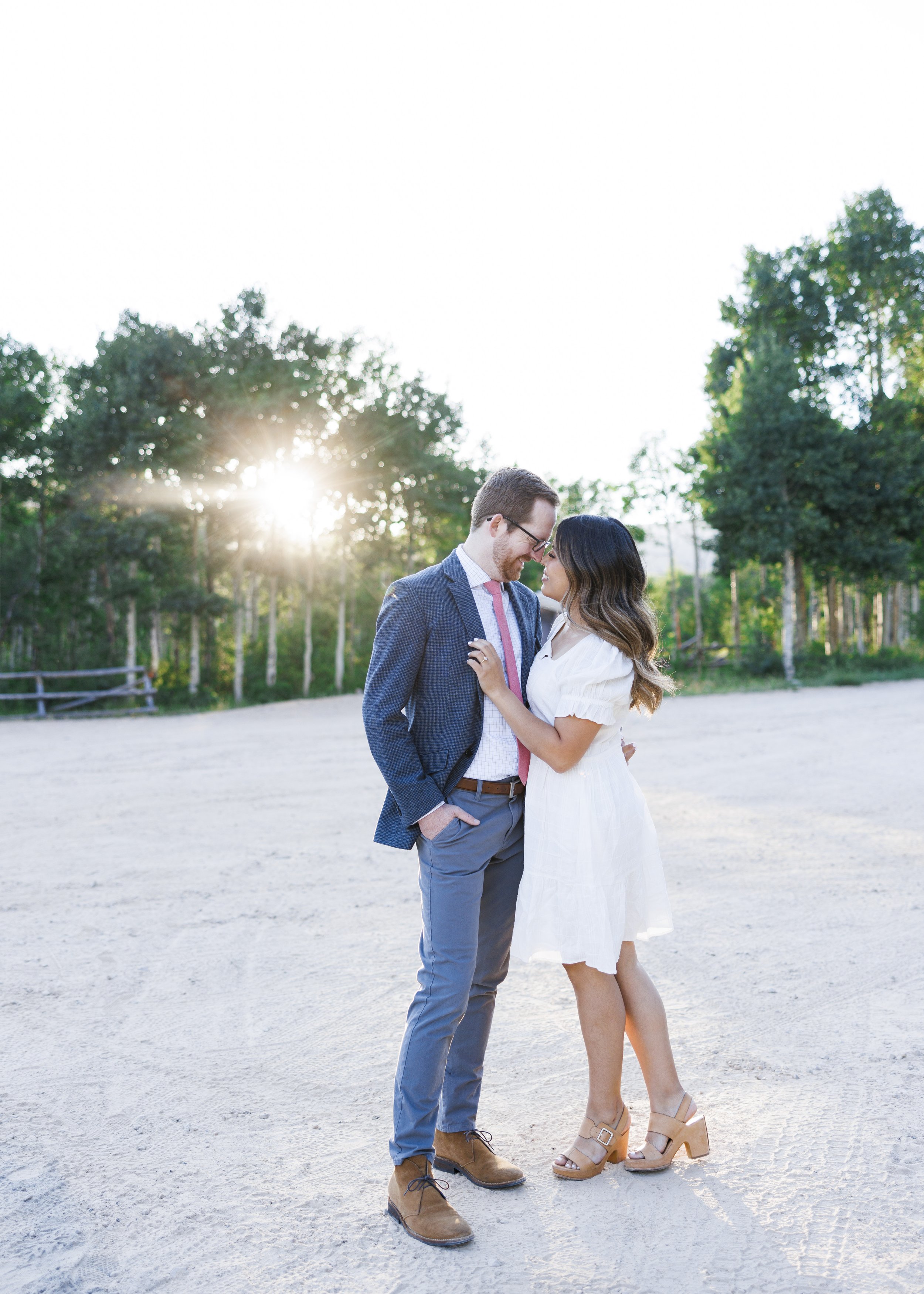  With the sun setting behind them an engaged couple kiss while wearing classy clothing by Savanna Richardson Photography. Pro Photographers #ParkCityEngagements #ParkCityPhotographers #SavannaRichardsonPhotography #SavannaRichardsonEngagements 