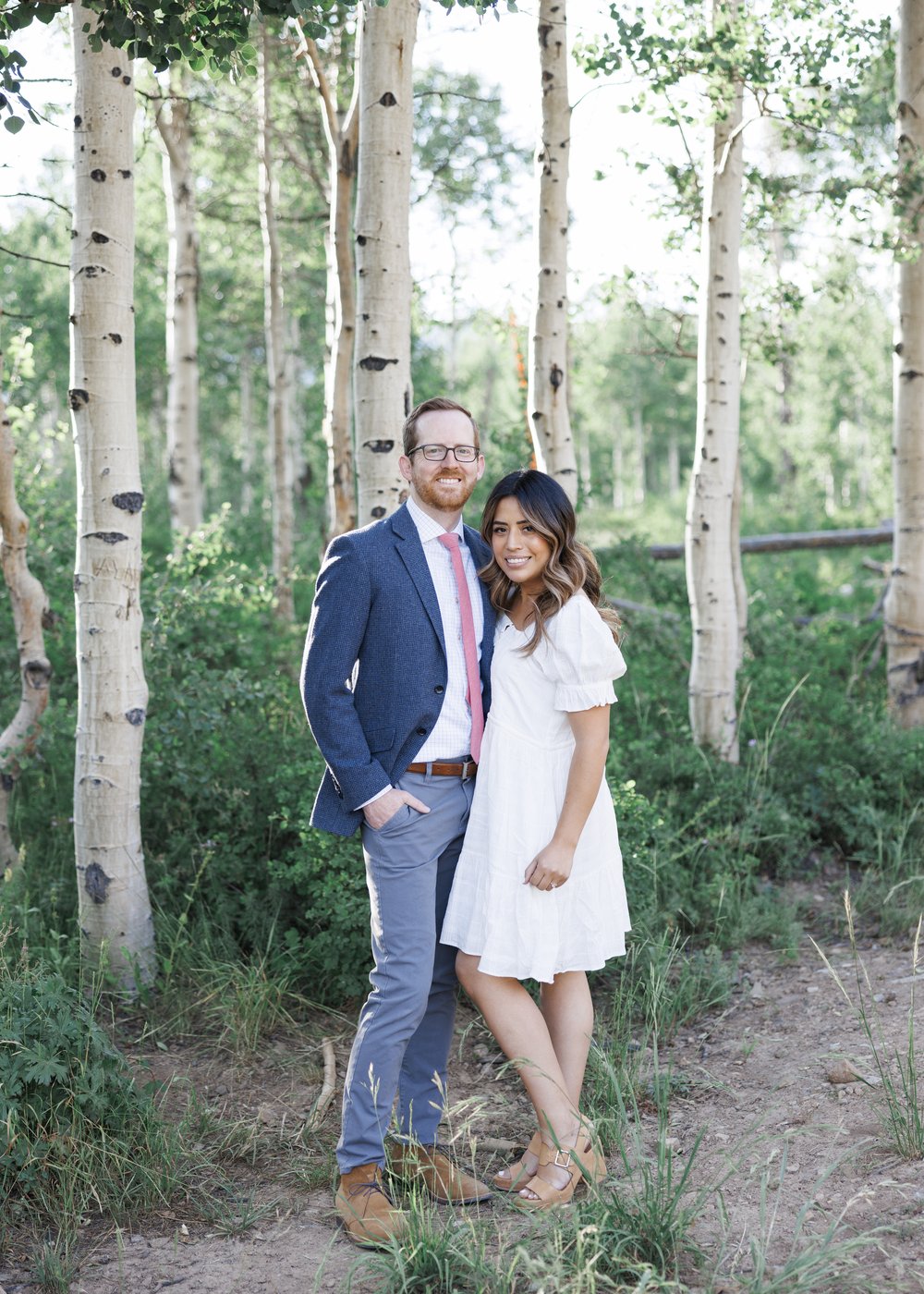  woman in a white flowy dress and a man in blue suit take engagements in the Park City mountains by Savanna Richardson Photography. outdoor #ParkCityEngagements #ParkCityPhotographers #SavannaRichardsonPhotography #SavannaRichardsonEngagements   