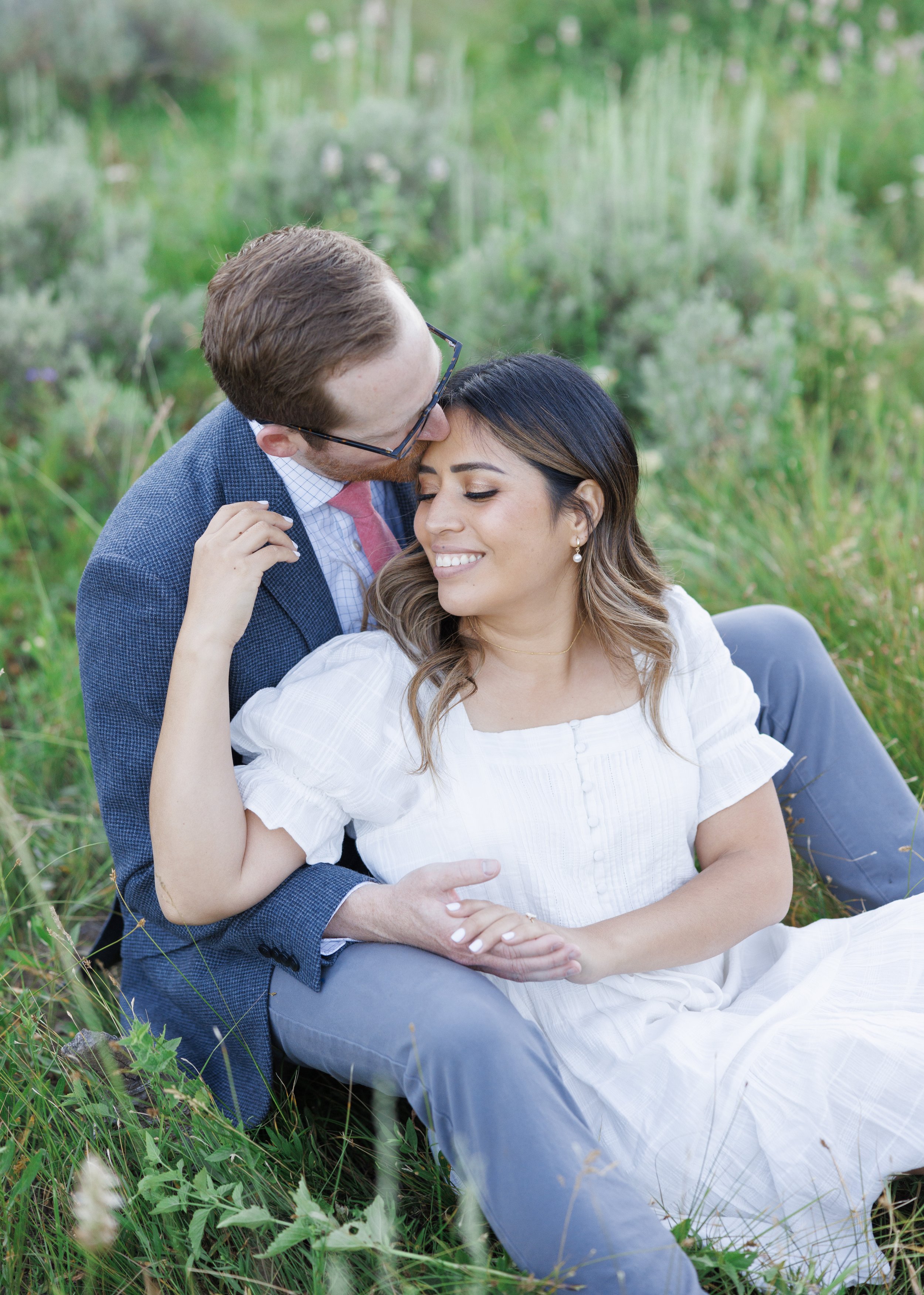  In a mountain meadow in Park City, a man kisses the top of a woman's head by Savanna Richardson Photography. white engagement dress meadow #ParkCityEngagements #ParkCityPhotographers #SavannaRichardsonPhotography #SavannaRichardsonEngagements   