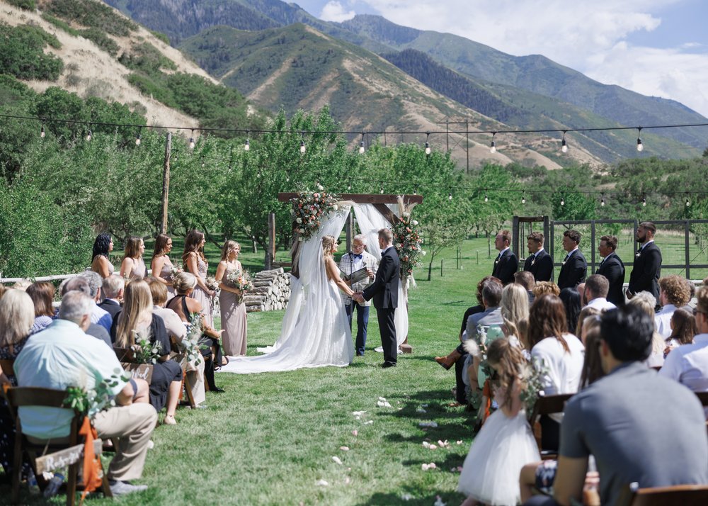  Savanna Richardson Photography captures a bride and groom at the altar on a green meadow in Utah. Outdoor wedding venues Utah photographers #SavannaRichardsonPhotography #SavannaRichardsonWeddings #QuietMeadowFarms #MapletonUTweddingphotographers 